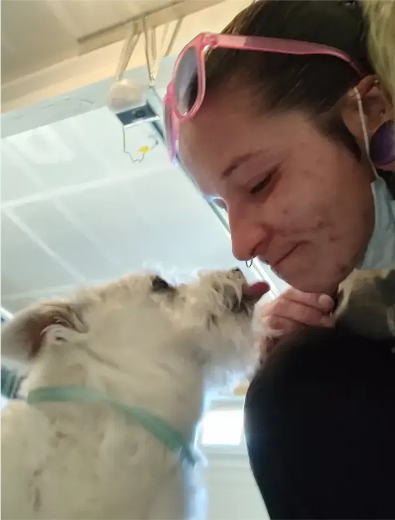 A Padfoot trainer sharing a quiet, trusting moment with a small dog, emphasizing the importance of building a bond through calm interaction.