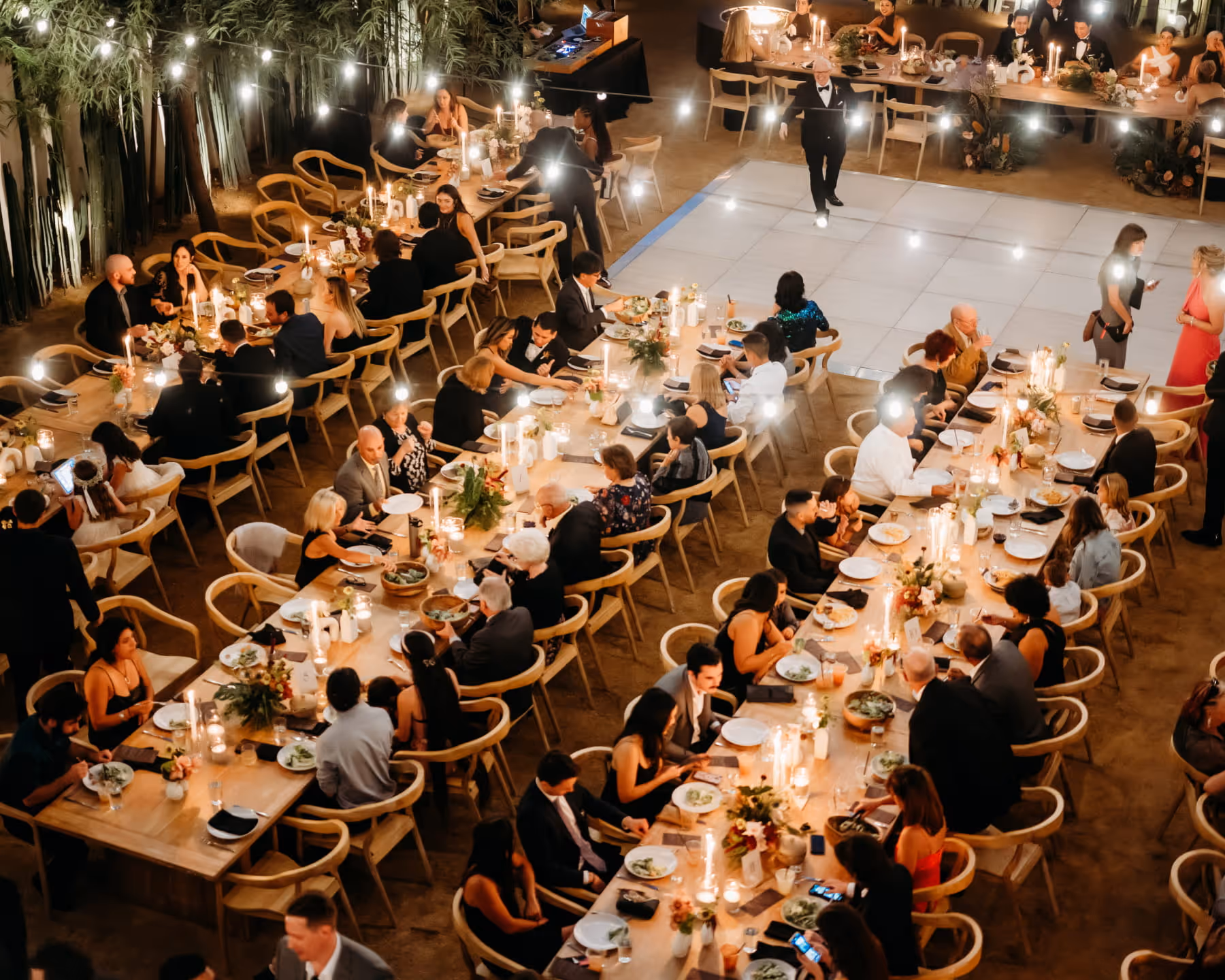 Wedding table number 5 with floral centerpiece of blush roses, wildflowers, and greenery in warm sunlight