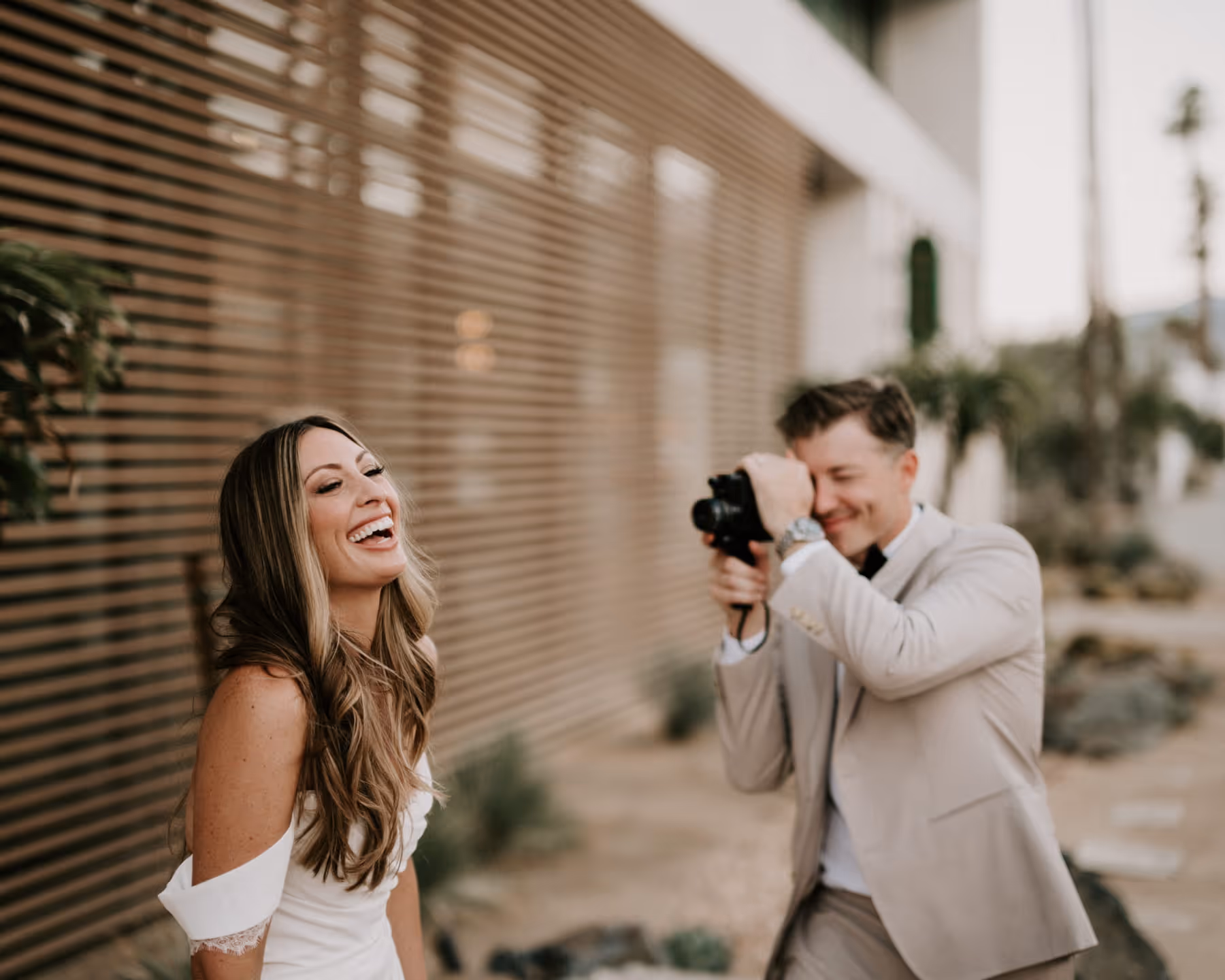 Wedding reception dinner with long wooden tables, candlelight, and guests enjoying food and conversation