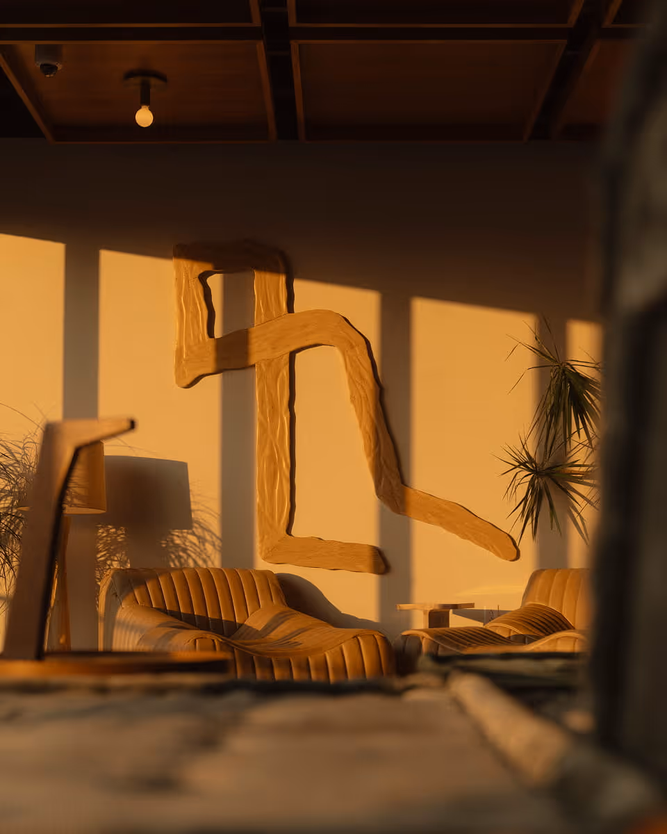 Warm golden-hour light fills a lounge with ribbed chairs, tropical plants, and an abstract wooden wall sculpture