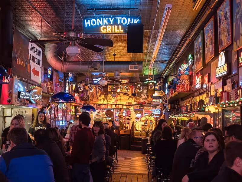 Crowded Robert's Western World honky tonk bar on Broadway in Nashville with neon signs and live music stage.
