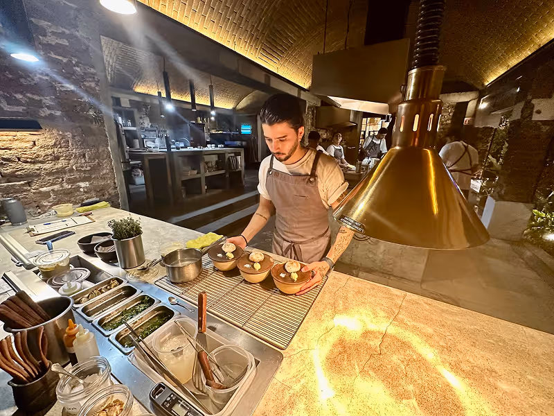 Chef preparing fresh seafood in the open kitchen at Kitchen Table restaurant in San Jose del Cabo