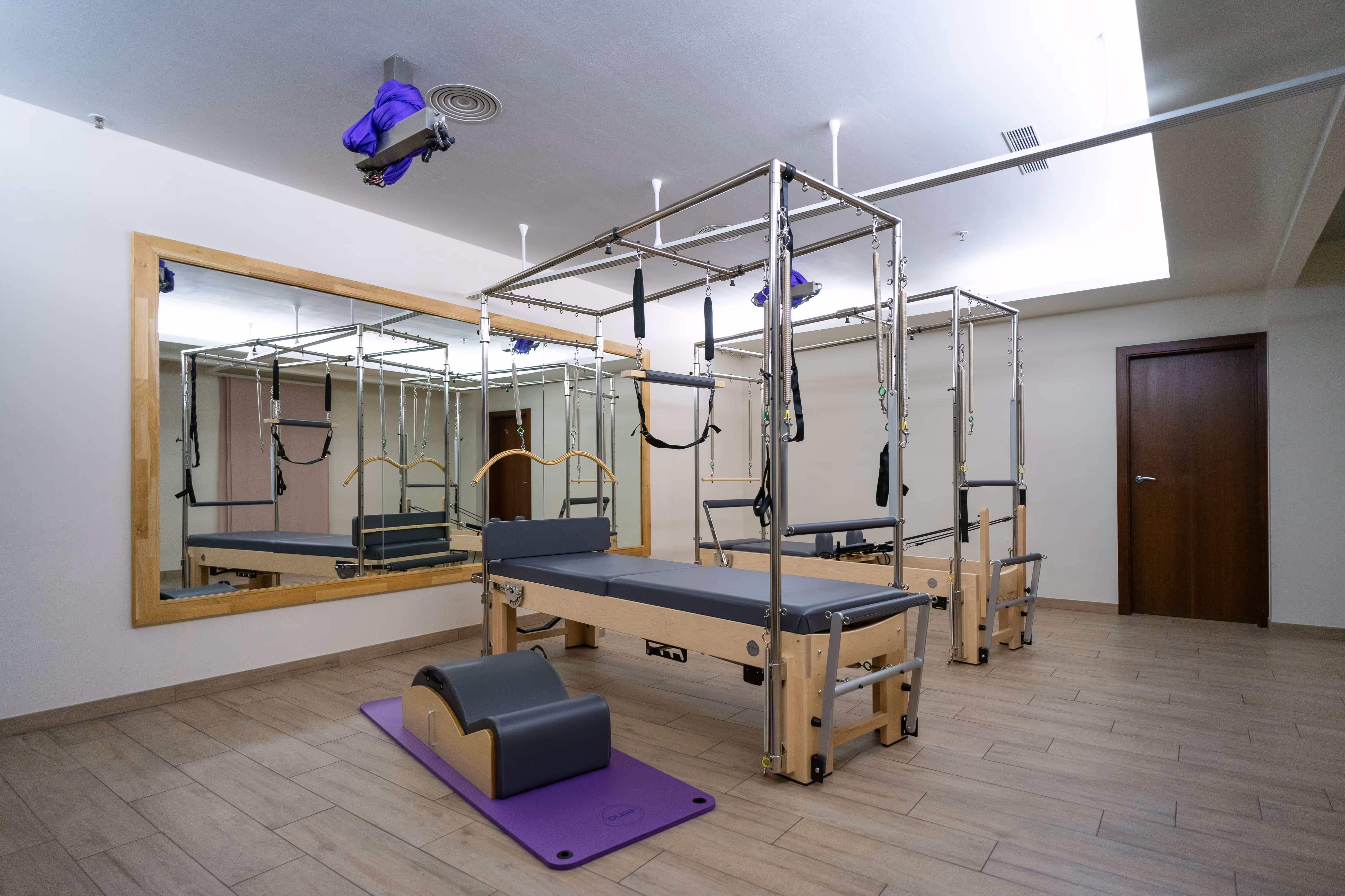 Premium-Fitness-Einrichtungen im modernen Fitness-Zentrum im Herzen Wiens mit Pilates-Reformern und Trainingsmatten.