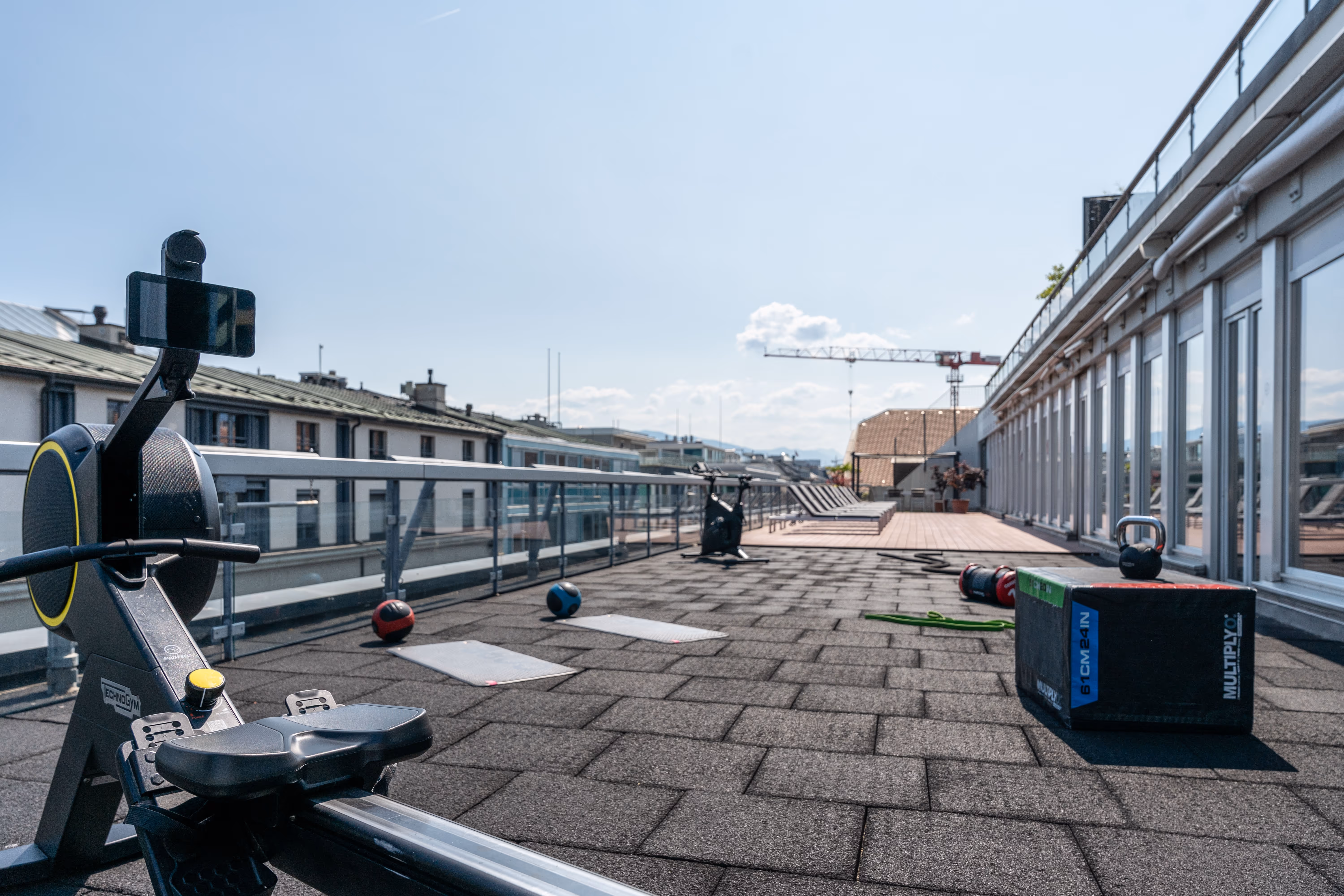 State-of-the-art fitness area mit Exerzierausrüstung für Krafttraining und Cardio-Training auf Dachterrasse.