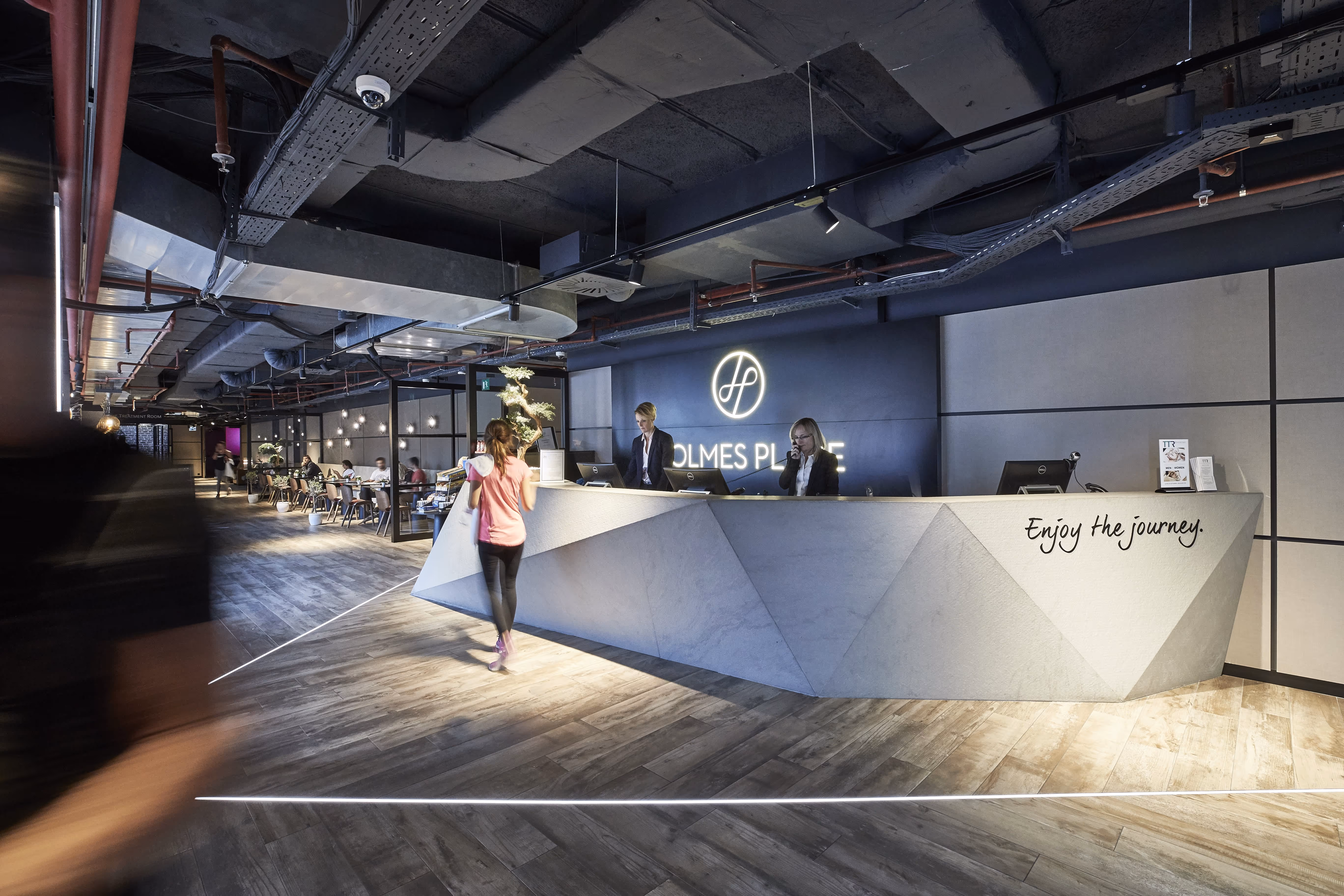 Gäste und Personal in einem umfassenden Fitnessbereich in einem Premium-Fitness-Studio in Wien.