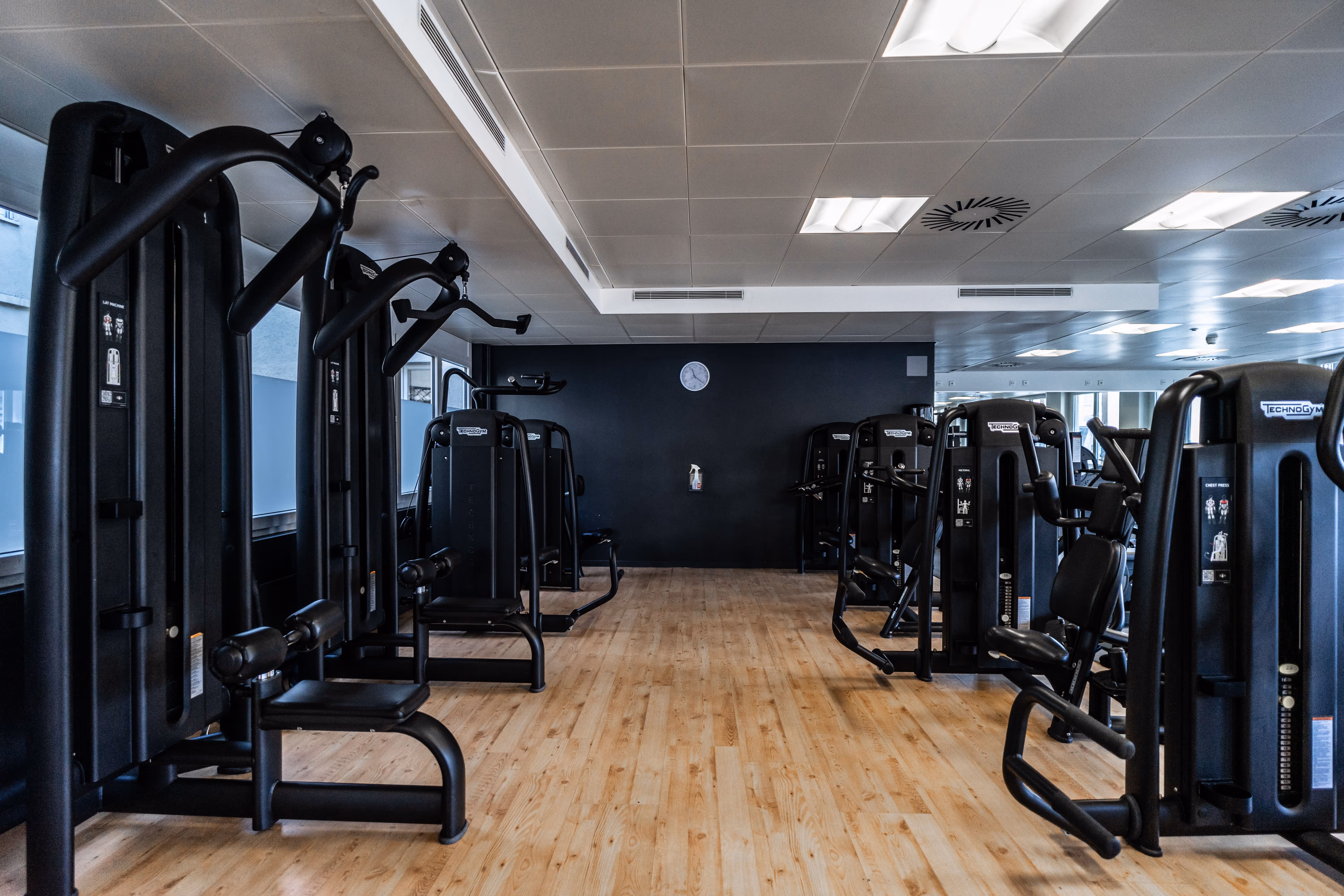 Modern fitnessraum mit professionellen Sportgeräten und massivem Holzboden in Wien für Gesundheit.