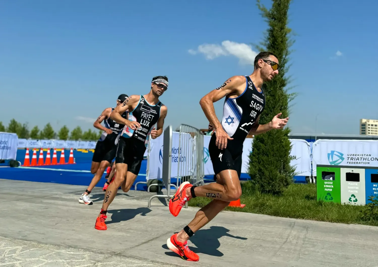 Drei Triathleten auf der Laufstrecke einer Mitteldistanz bei Sonne