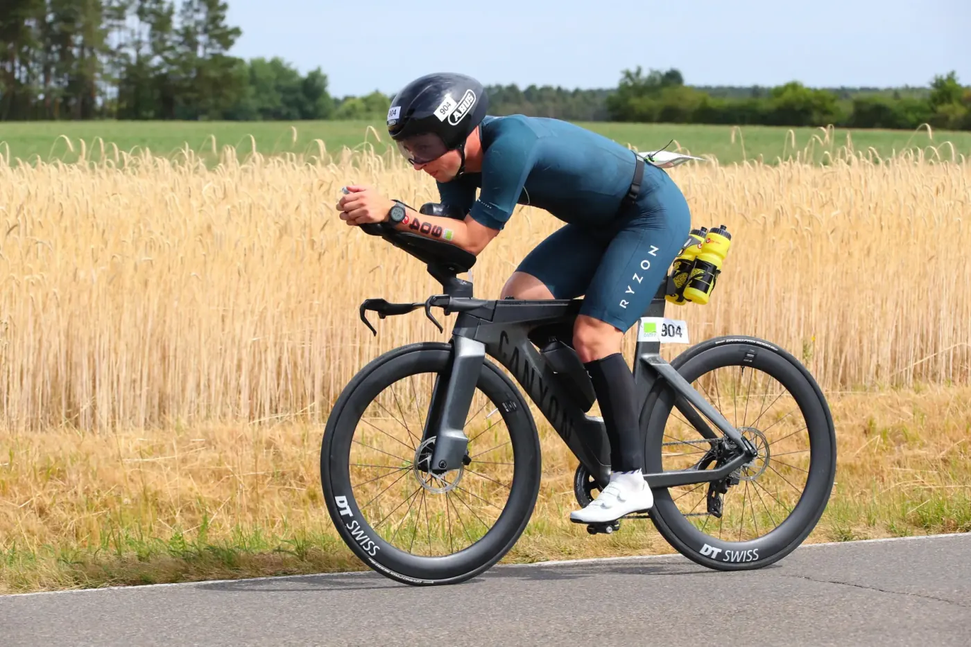 Triathlet in Aeroposition vor einem Weizenfeld bei der Challenge Roth