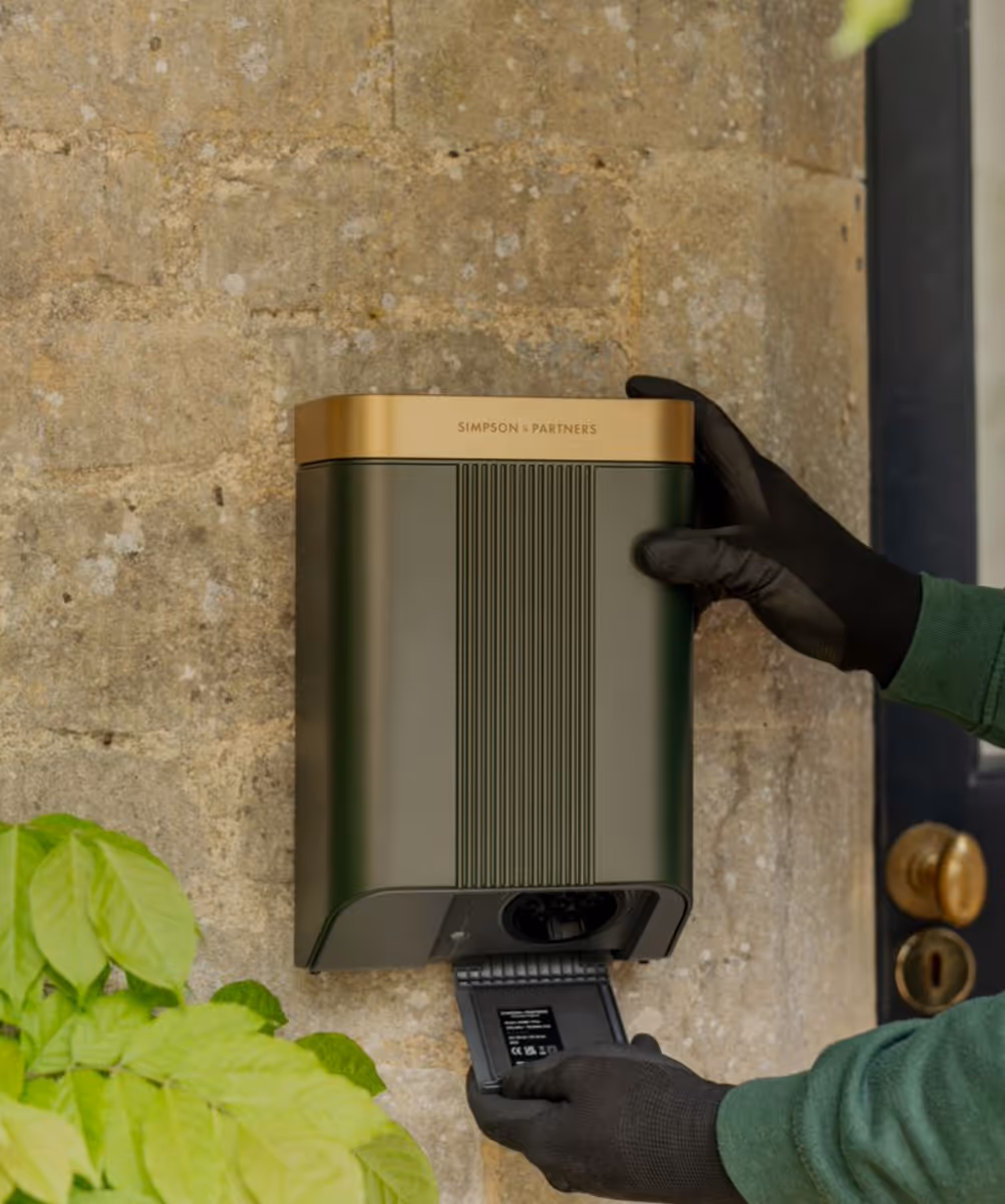 Simpson + Partners EV charger mounted on textured wall with green leaves