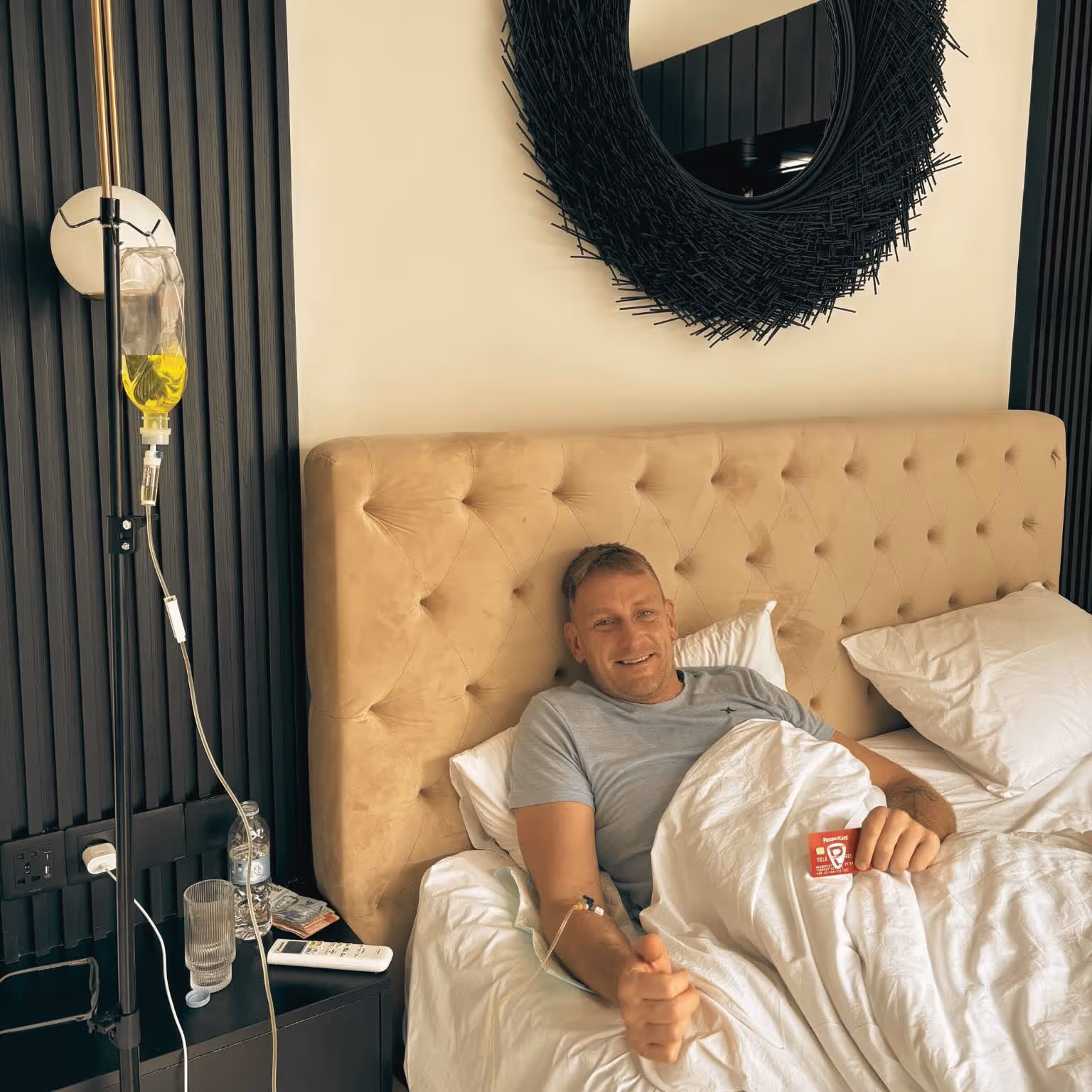 Das Bild zeigt Dennis Rehm, wie er erkrankt auf Bali im Bett liegt und durch Passport Card eine ausgezeichnete medizinische Versorgung erfährt.