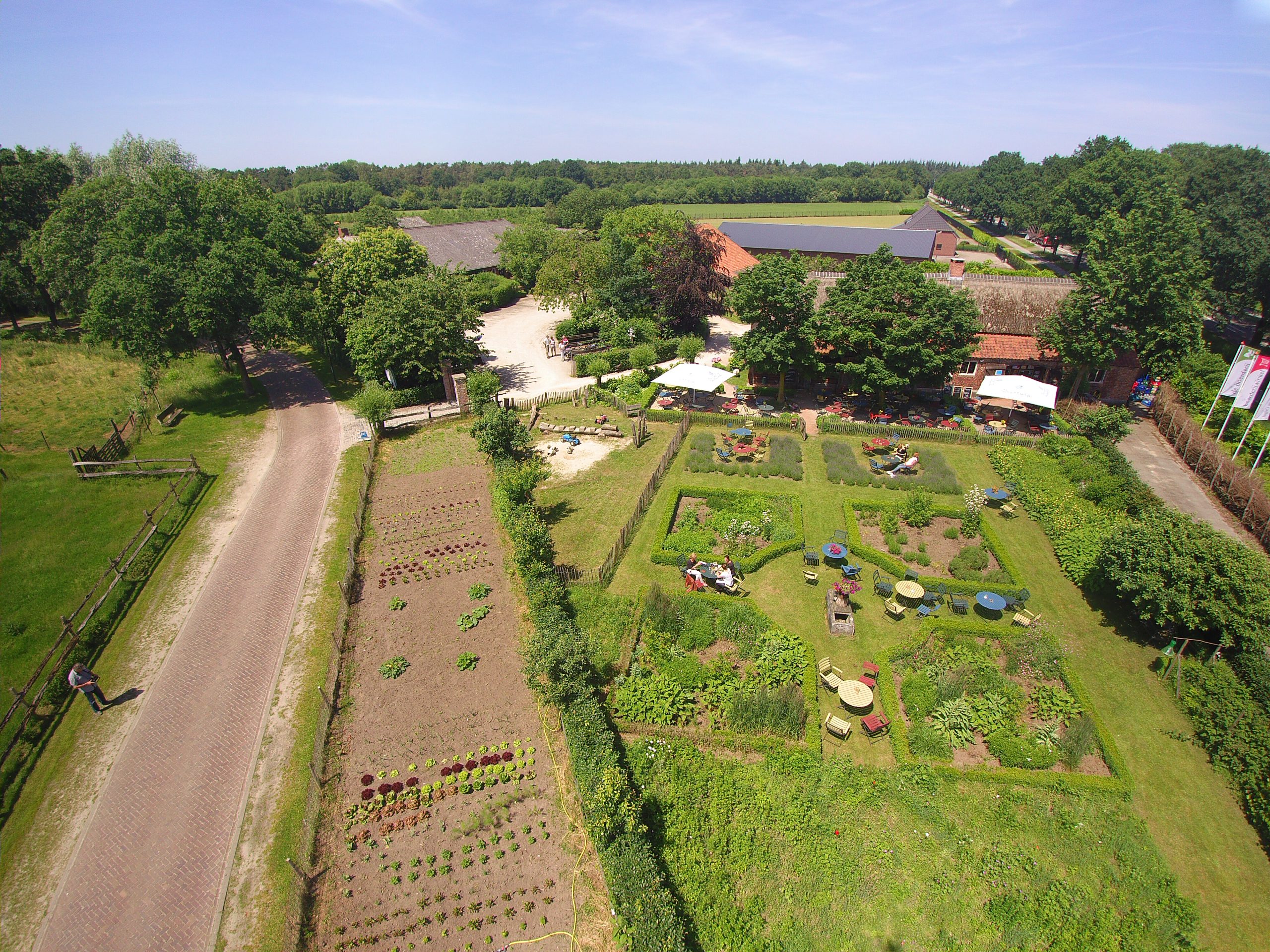 Luchtfoto van boerderij met tuin en terras.