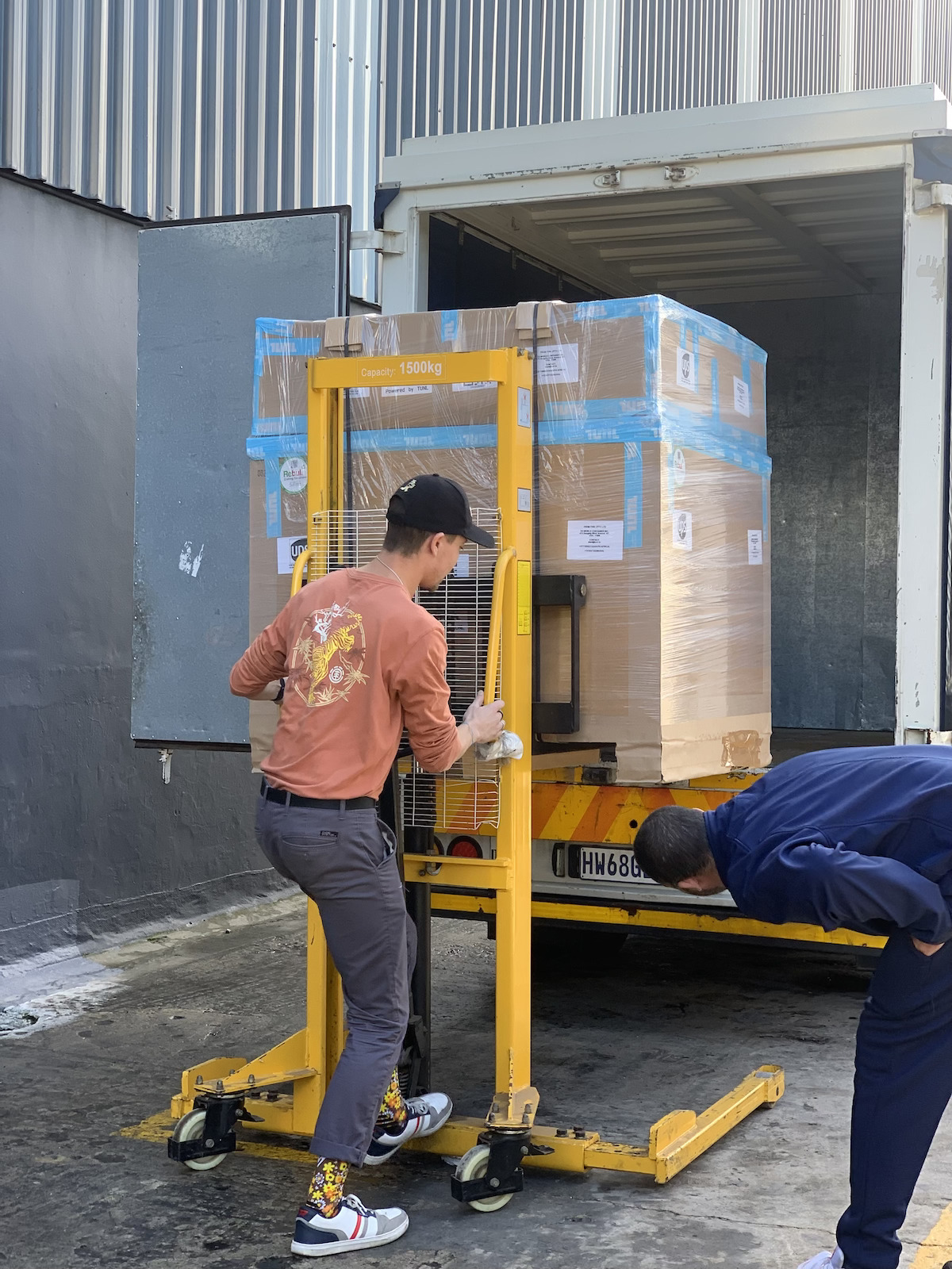TUNL team member loading boxes onto a truck for international delivery