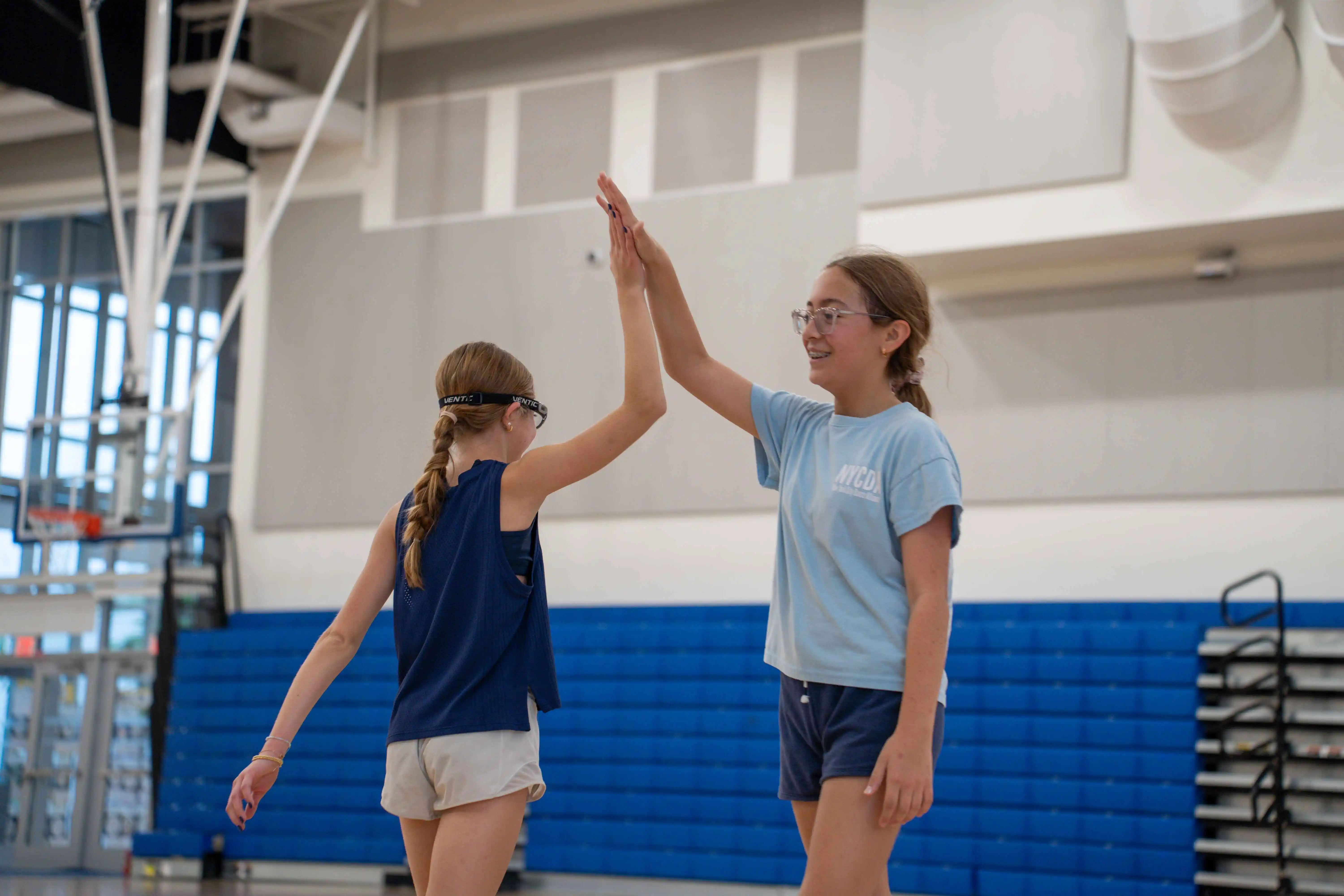 girls giving each other high five in basketball session