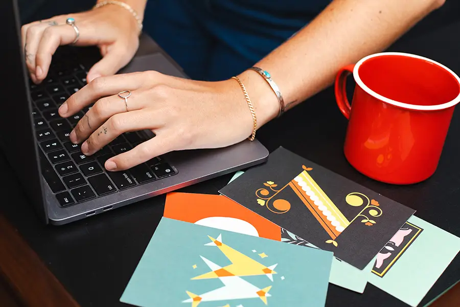 A close up of Alex Pesak, owner and Creative Director of AP the Creative, working at her laptop