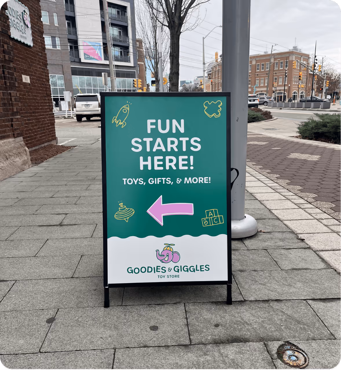 A frame signage design for Goodies and Giggle Toy Store on Mass Ave designed by AP The Creative.
