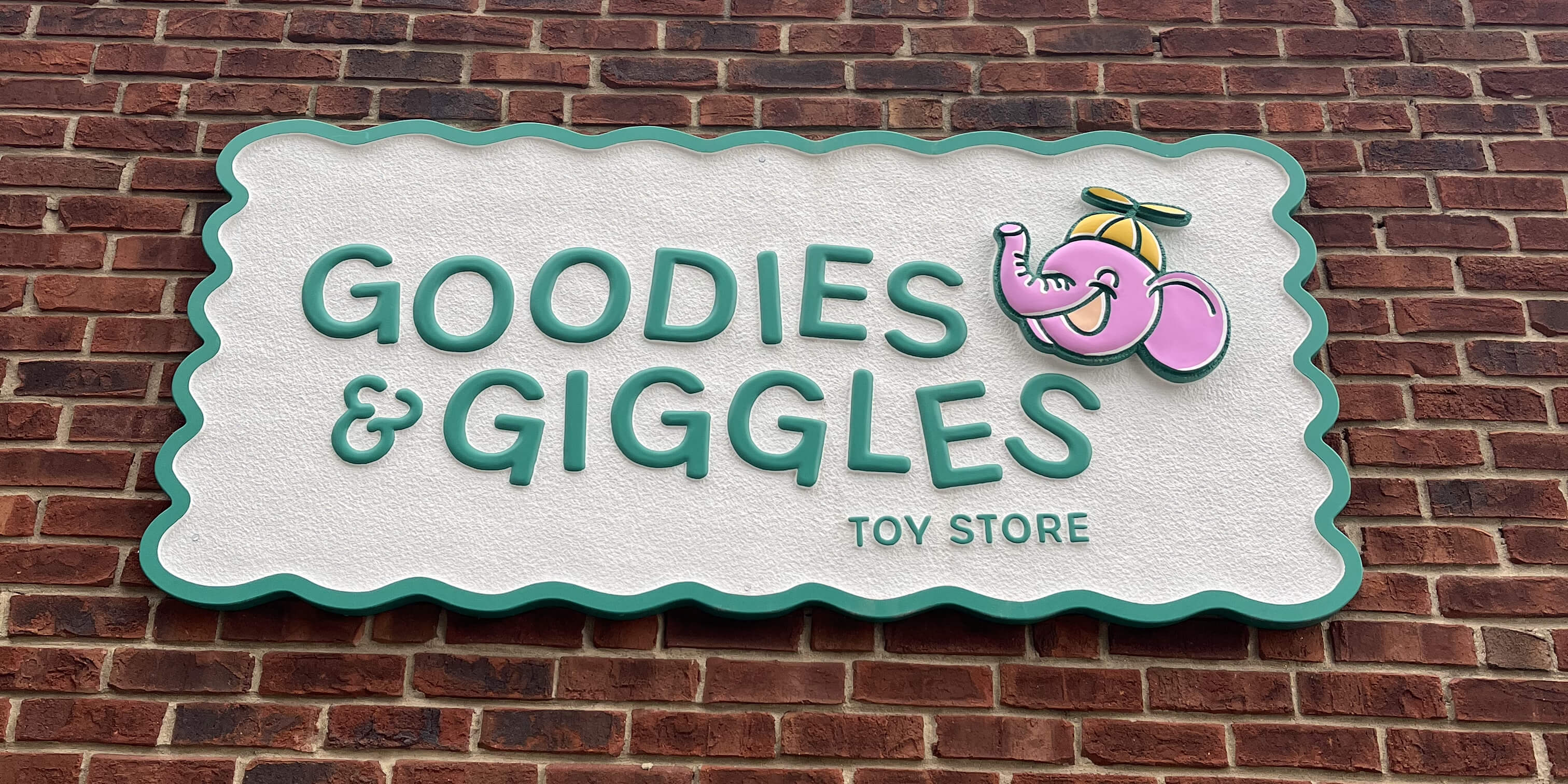 Goodies and Giggles Toy Store exterior signage of elephant mascot on Mass Ave Indianapolis designed by AP The Creative