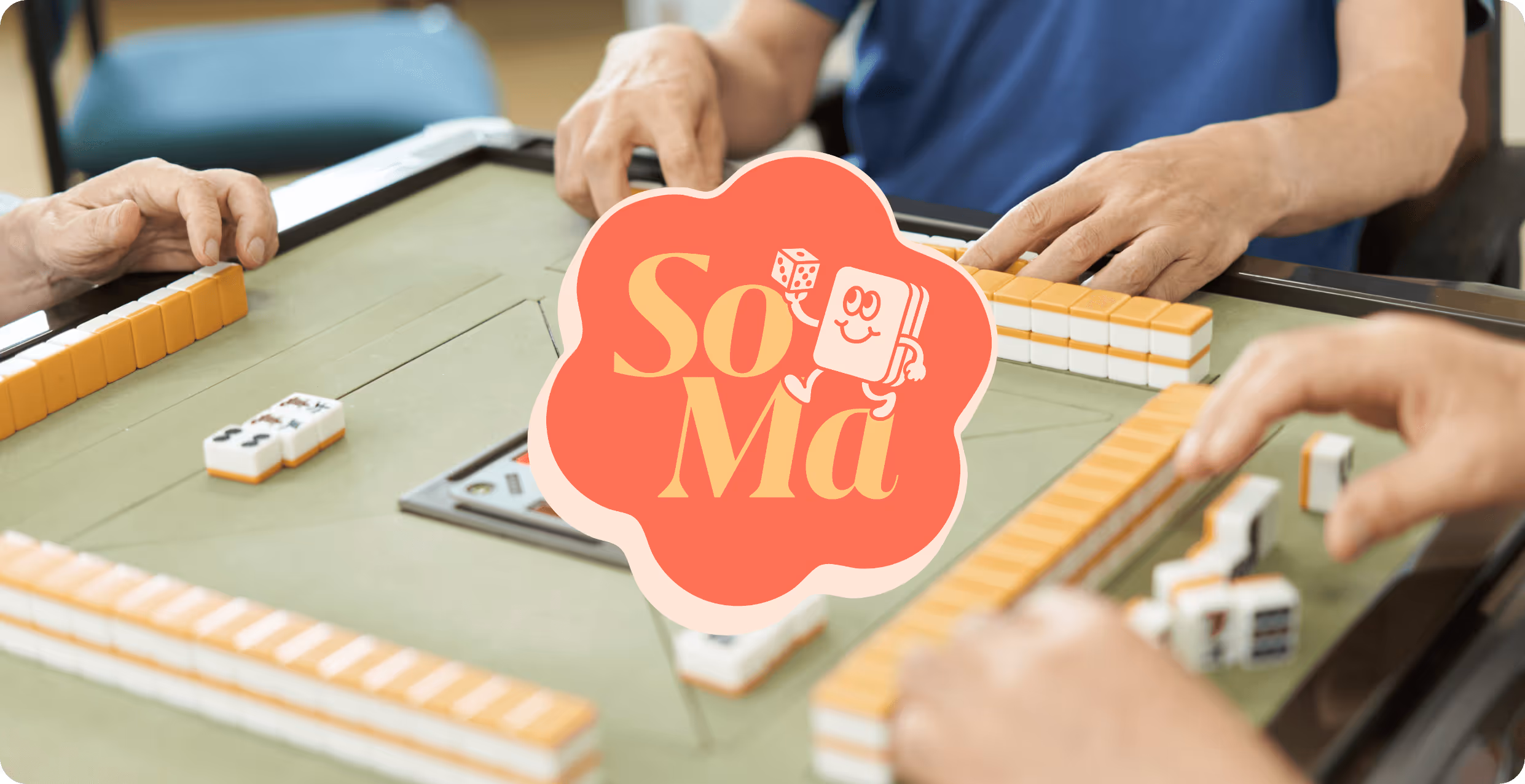 SoMa Mahjong Meetups photo of hands holding mahjong playing pieces and playing the game. Logo designed by AP The Creative.