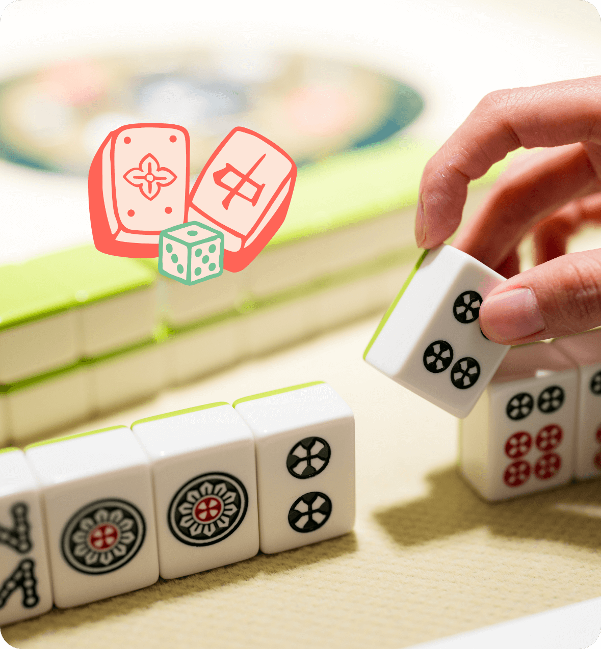 SoMa Mahjong Meetups photo of hand holding mahjong playing pieces. Game pieces logo designed by AP The Creative.
