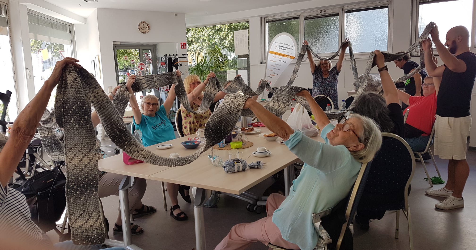 Viele Menschen halten einen sehr langen Schal hoch