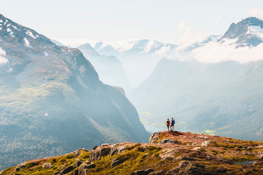 Tourists admiring the view from the top of a mountain in Loen Norway