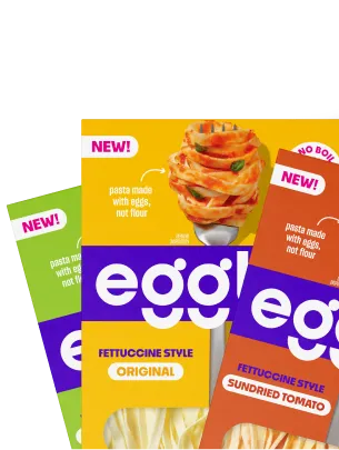 Three packages of Egglife pasta made with eggs, not flour, in original, sundried tomato, and spinach flavors with a fork twirling pasta.
