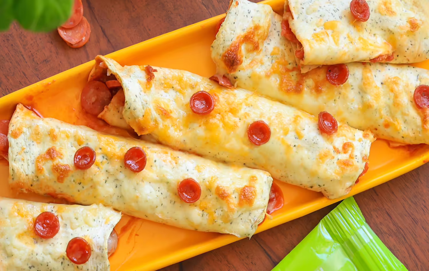 Pizza roll-ups made with egglife wraps, filled with pepperoni, melted cheese, and marinara sauce.