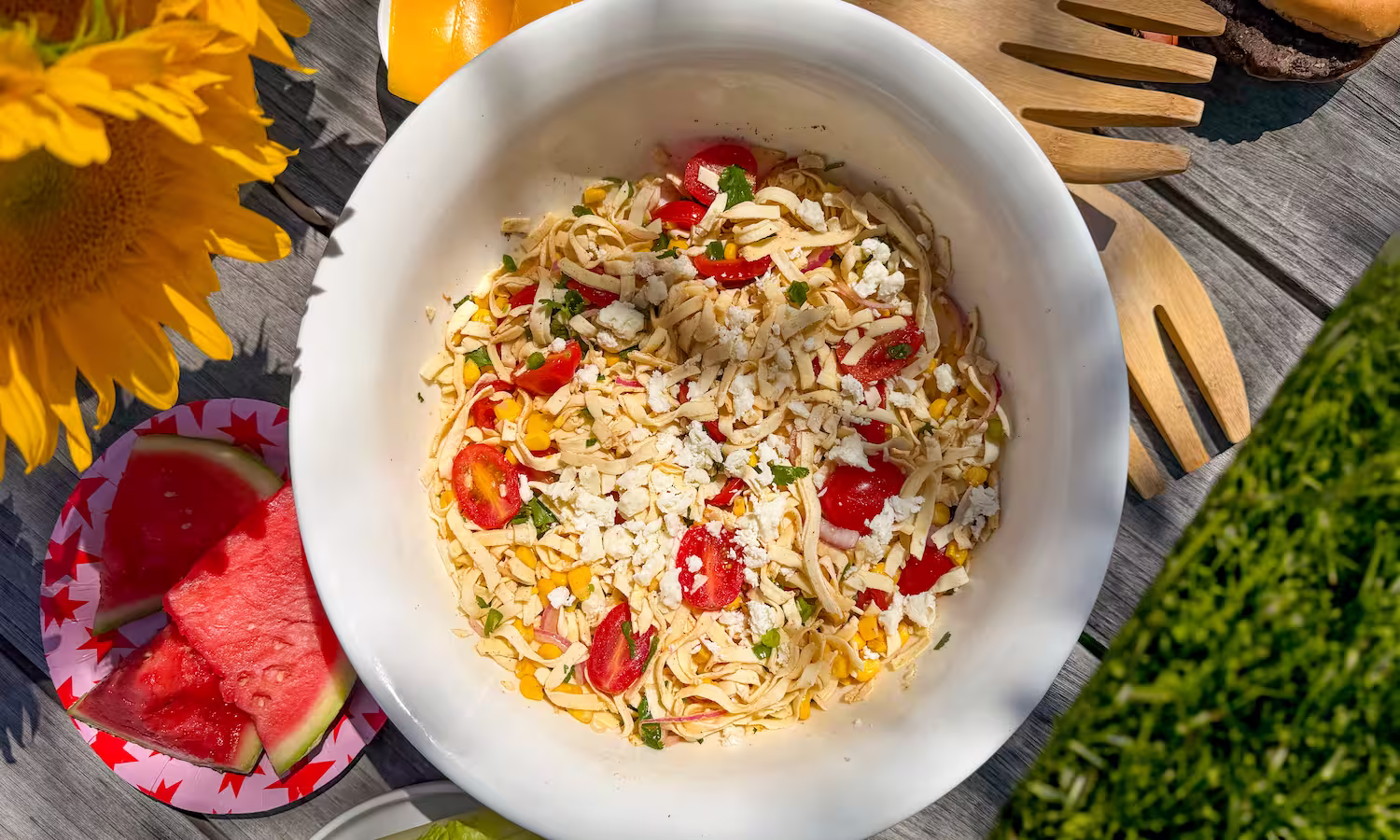 Pasta salad made with egglife power pasta, tossed with tomatoes, olives, cheese, salami, and fresh herbs in a white serving bowl. High protein low carb gluten free 