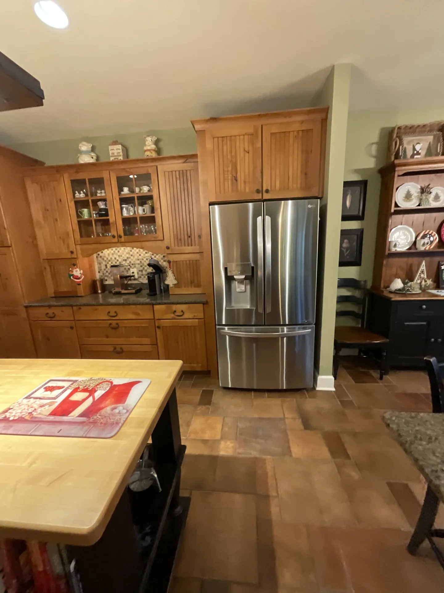 Kitchen before remodeling showing the original cabinetry, refrigerator area, and adjacent dining space.
