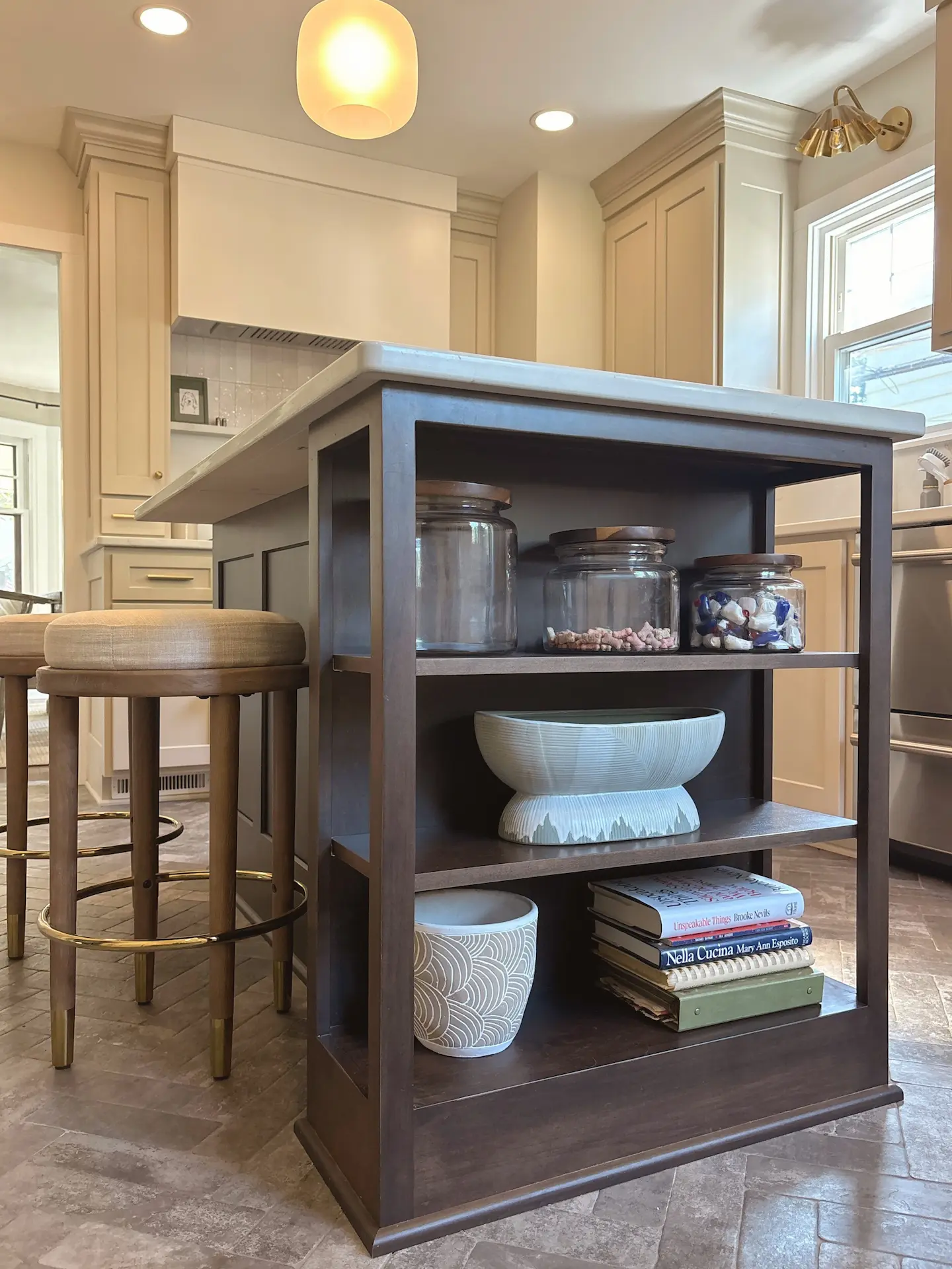 Custom kitchen island with dark wood open shelving, quartz countertop and bar seating