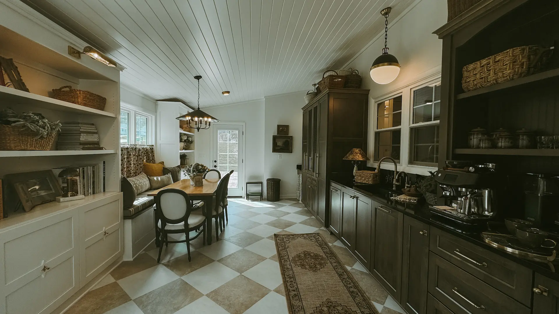 English country-inspired butler’s pantry with custom cabinetry, open shelving and adjoining dining area
