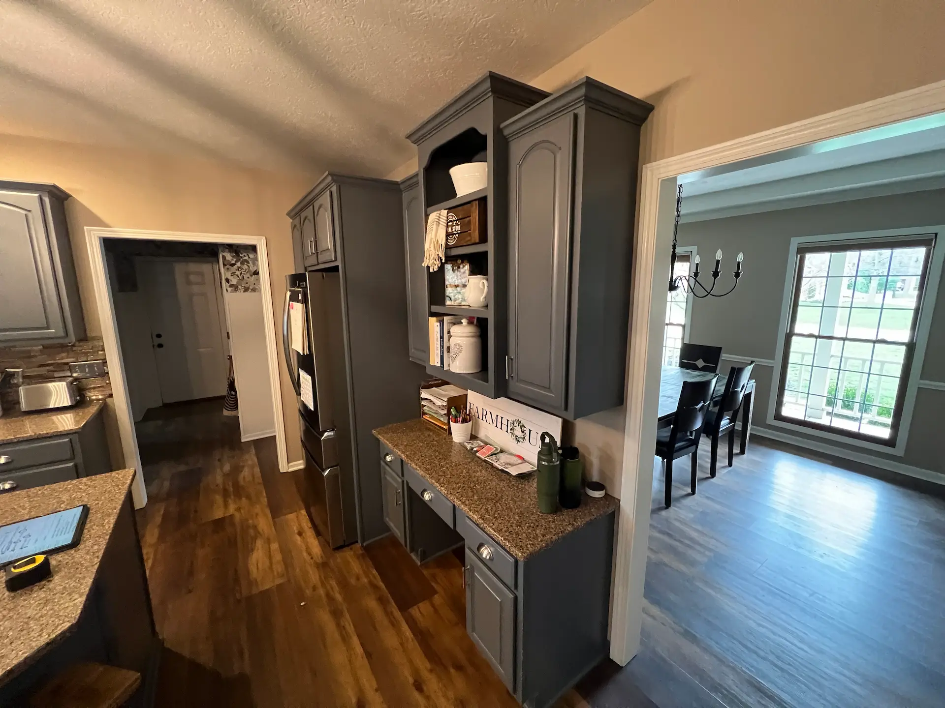Kitchen before renovation showing gray cabinetry and built-in storage beside the dining room