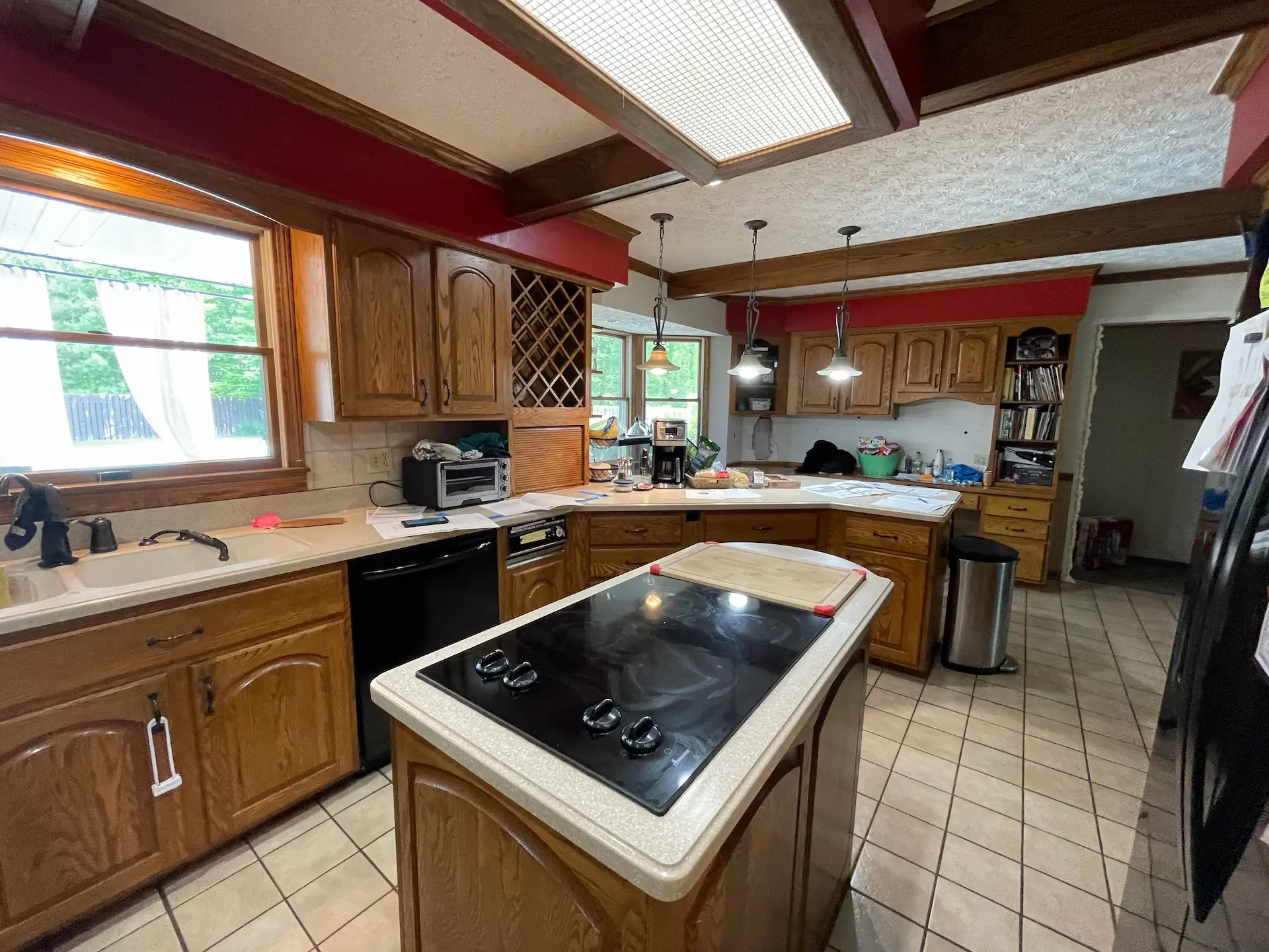 Remodeled kitchen with white cabinets, subway tile backsplash, black appliances, and a large island with seating for four.