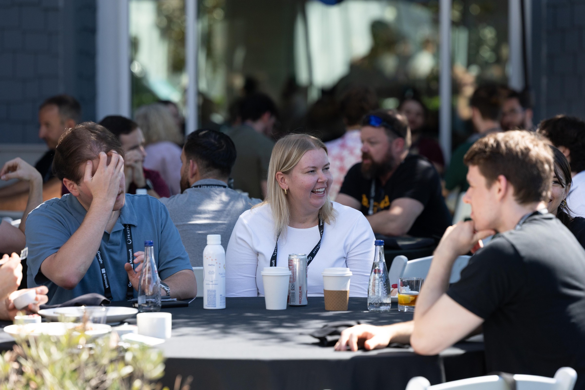Attendees sharing a lighthearted conversation during the daytime lunch break.