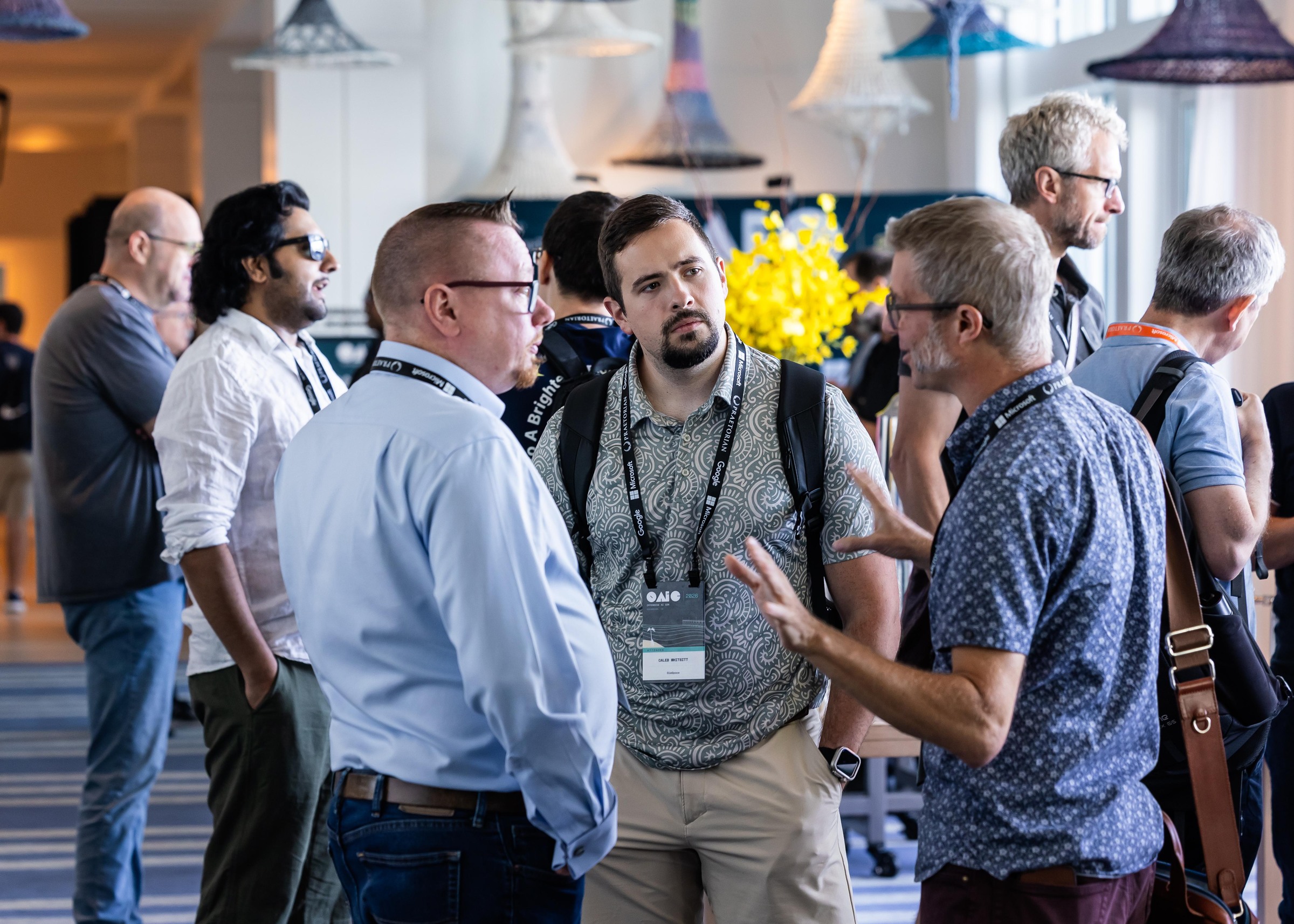Attendees engaged in a small-group discussion in the conference foyer.
