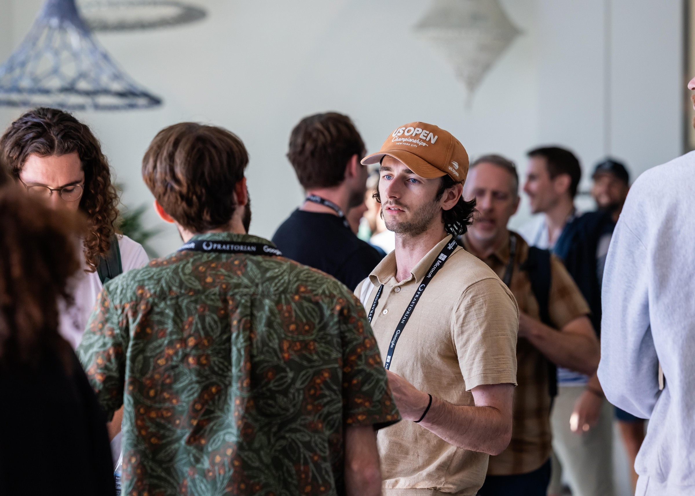 Attendees continuing a conversation in the foyer during a daytime conference break.