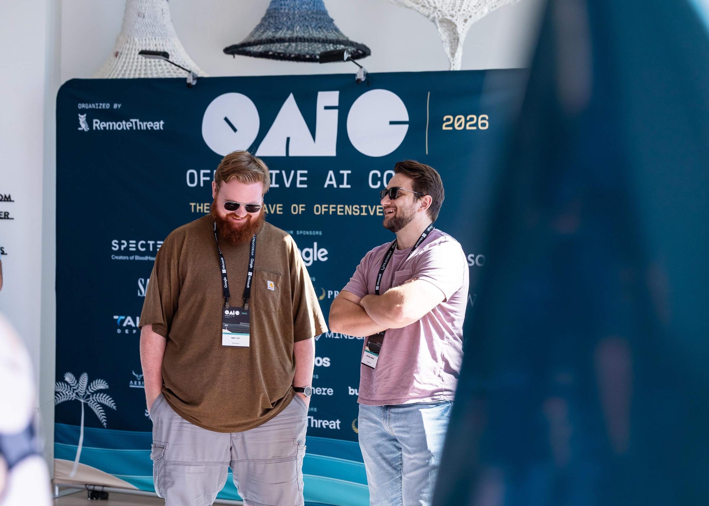 Two attendees sharing a laugh in the conference foyer.