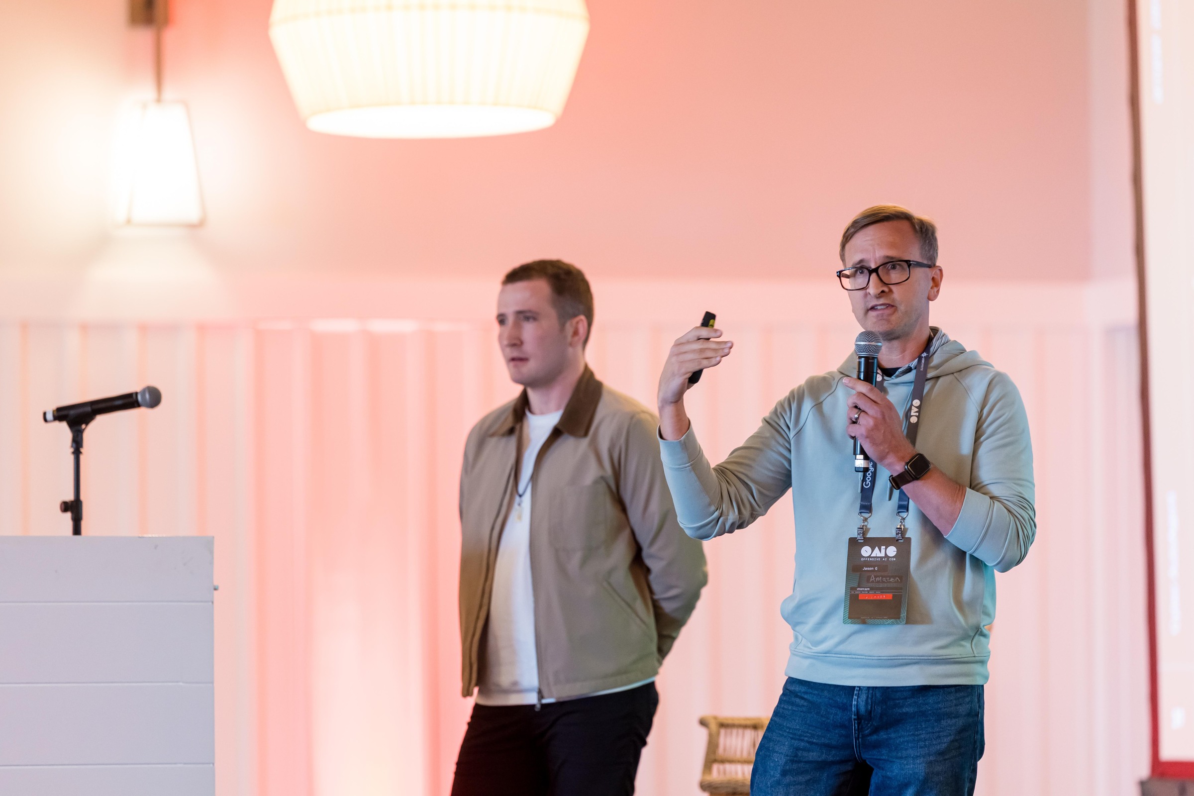 Two researchers discussing agent architectures on stage during a Tuesday session.
