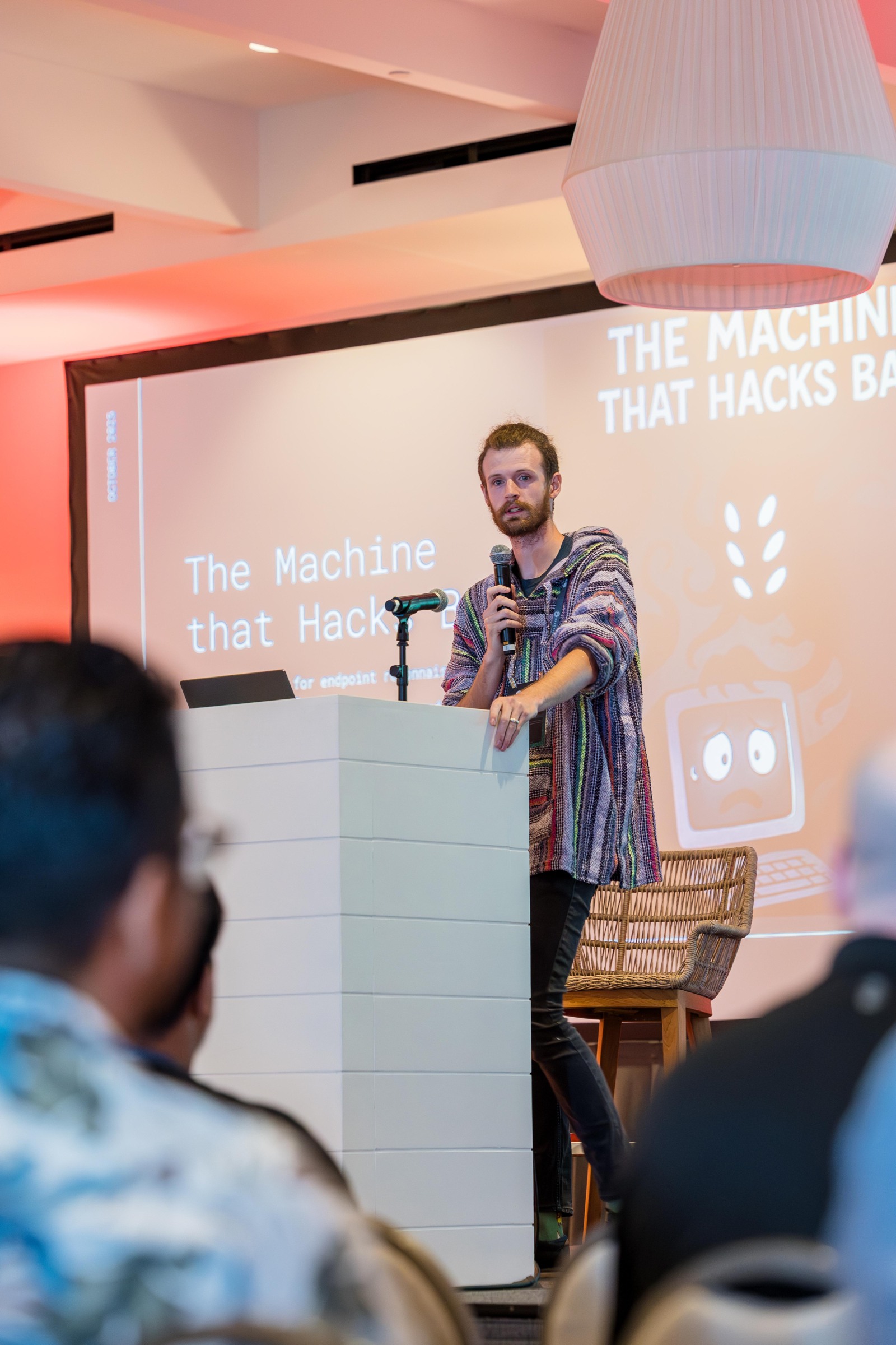 A researcher presenting The Machine that Hacks Back on the conference stage.