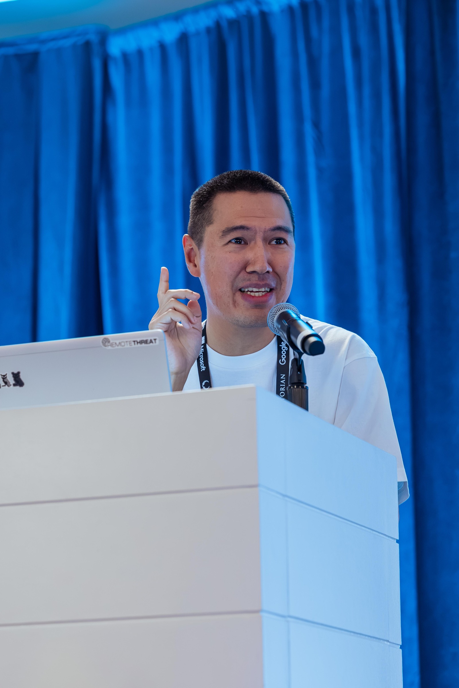 A presenter smiling and raising a finger while discussing an autonomous AI team.