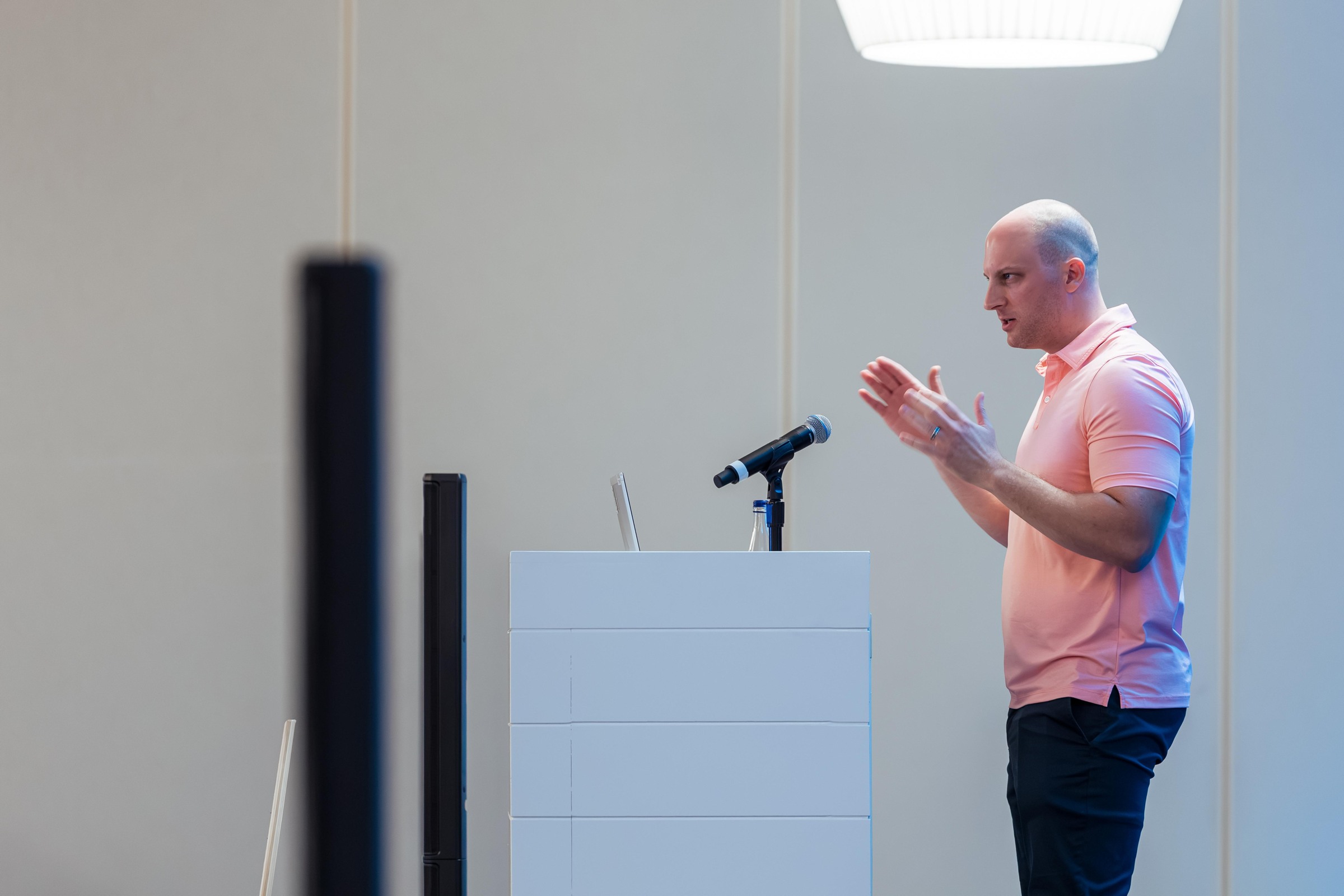 A researcher gesturing with both hands during All Models Cheat.