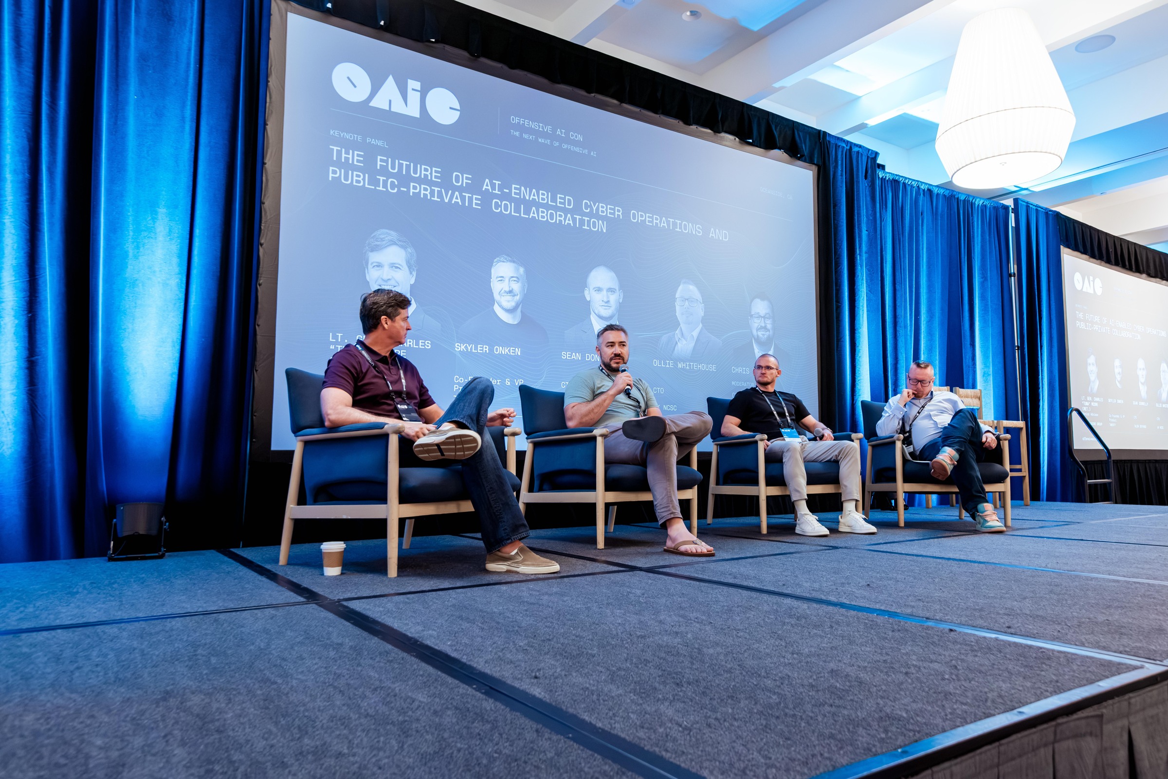 Four panelists discussing the future of AI-enabled cyber operations on the main stage.