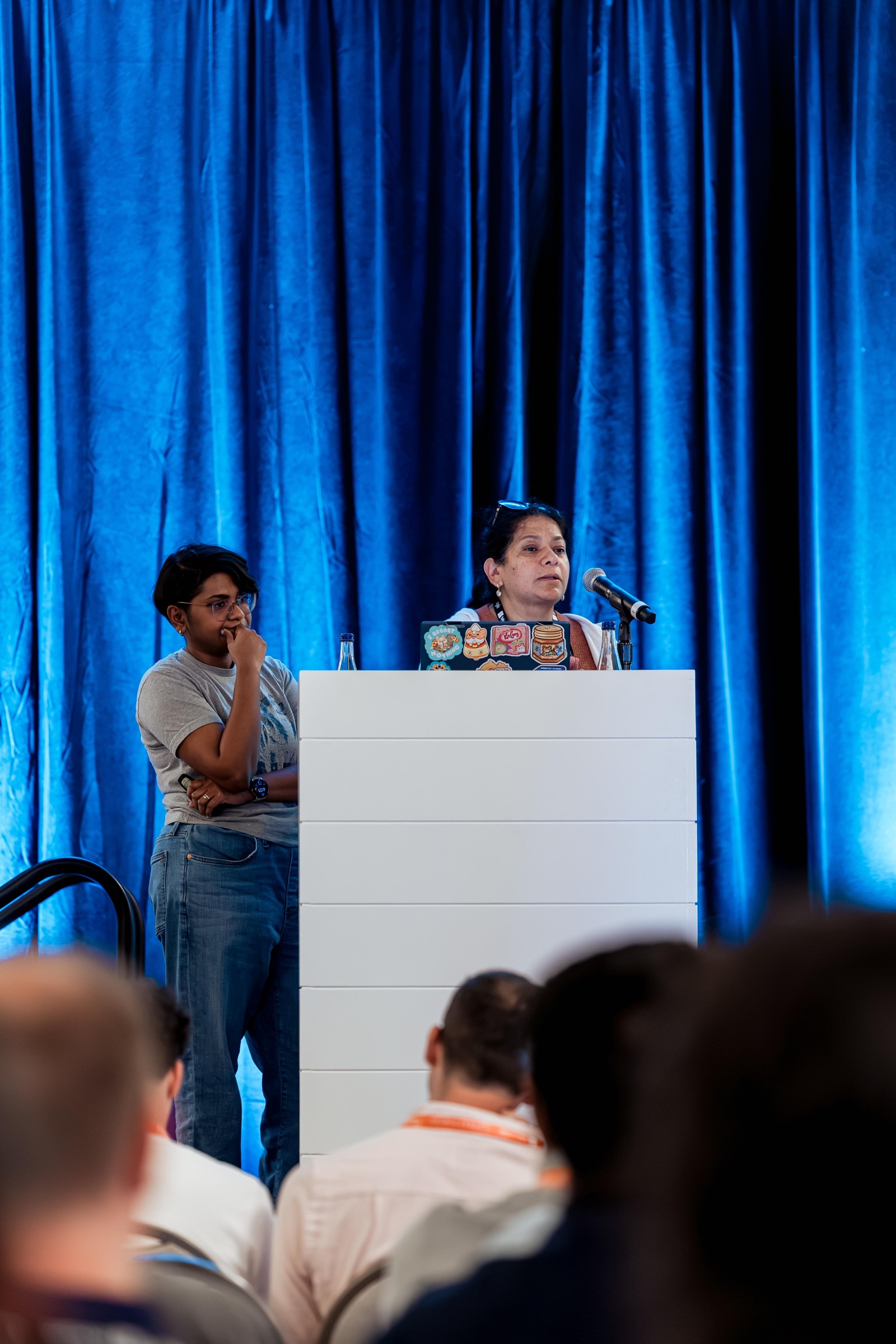 Two researchers at the lectern during Human in the Loop, Ghost in the Shell.