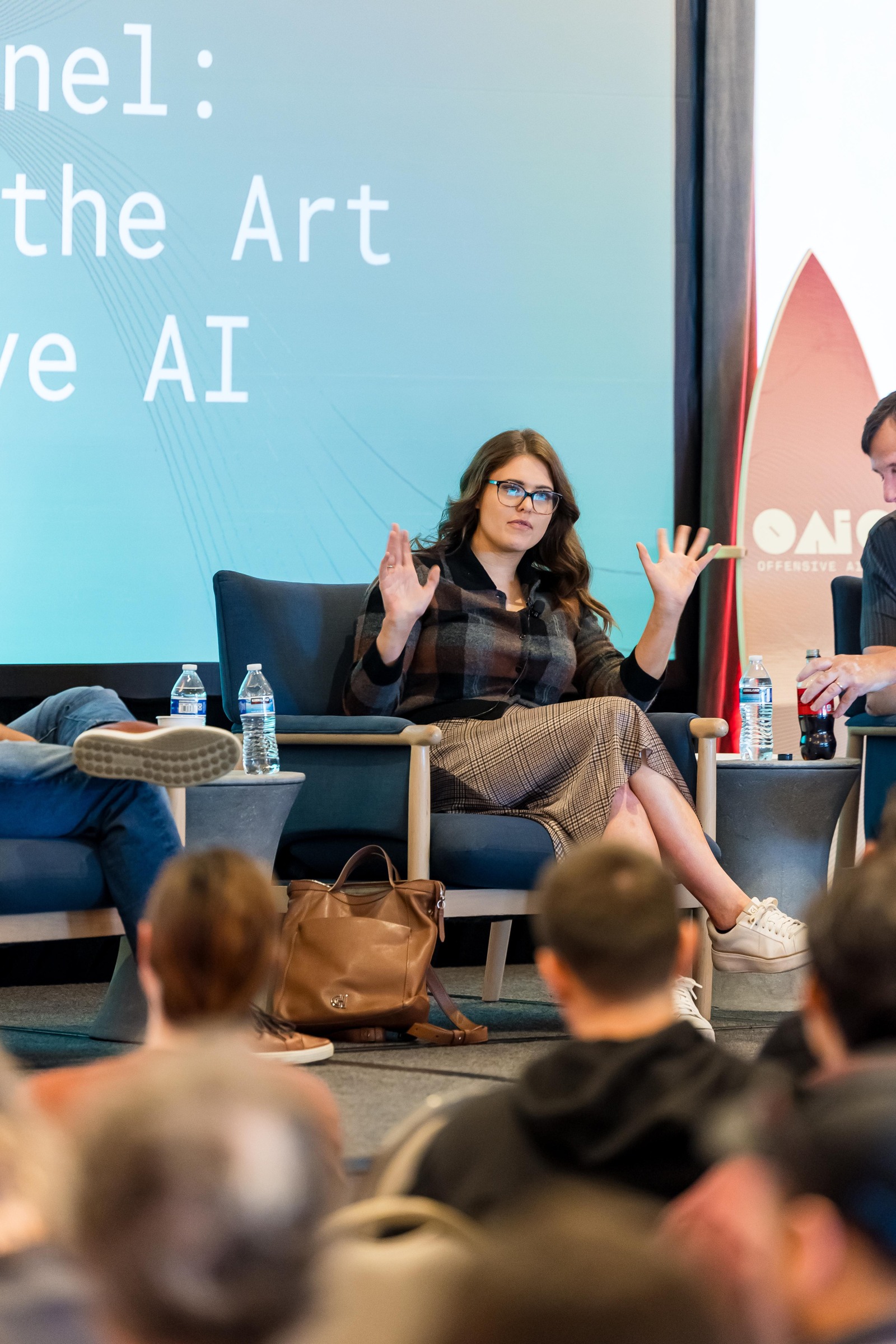A panelist gesturing while speaking during the State of the Art in Offensive AI keynote panel.