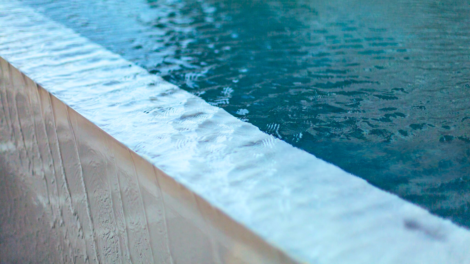 Close-up of a beveled pool window edge catching light for a luxury finish