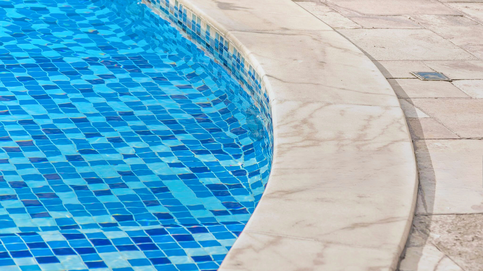 Textured paver coping surrounding a curved pool