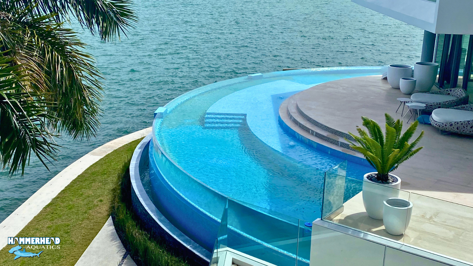 Curved frameless acrylic window at pool edge