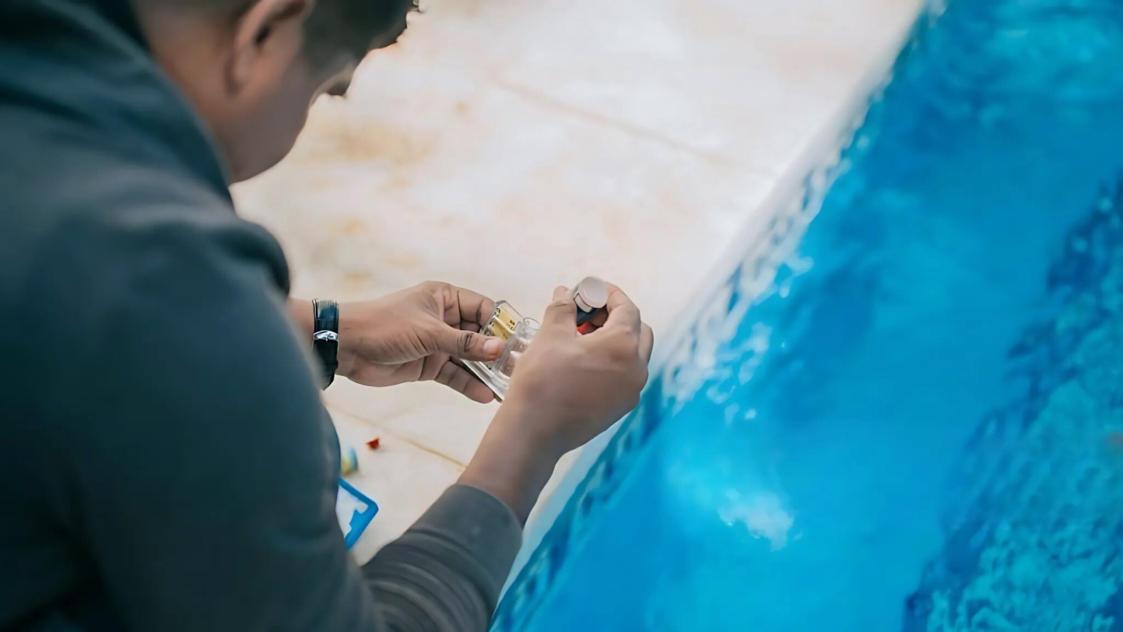 Testing chlorine and pH levels in pool water with a kit