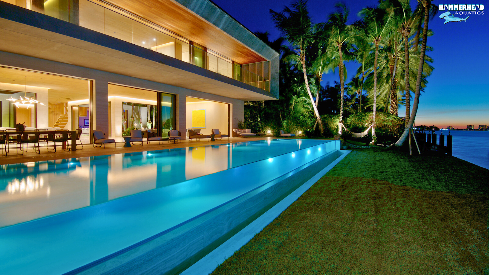 Luxury swimming pool with infinity edge, acrylic window, and modern lighting showcasing 2025 pool trends