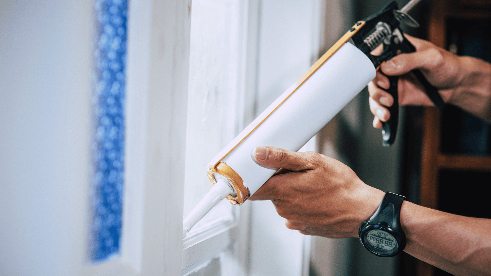 Applying waterproof slurry and sealing tape around tiled pool window frame.