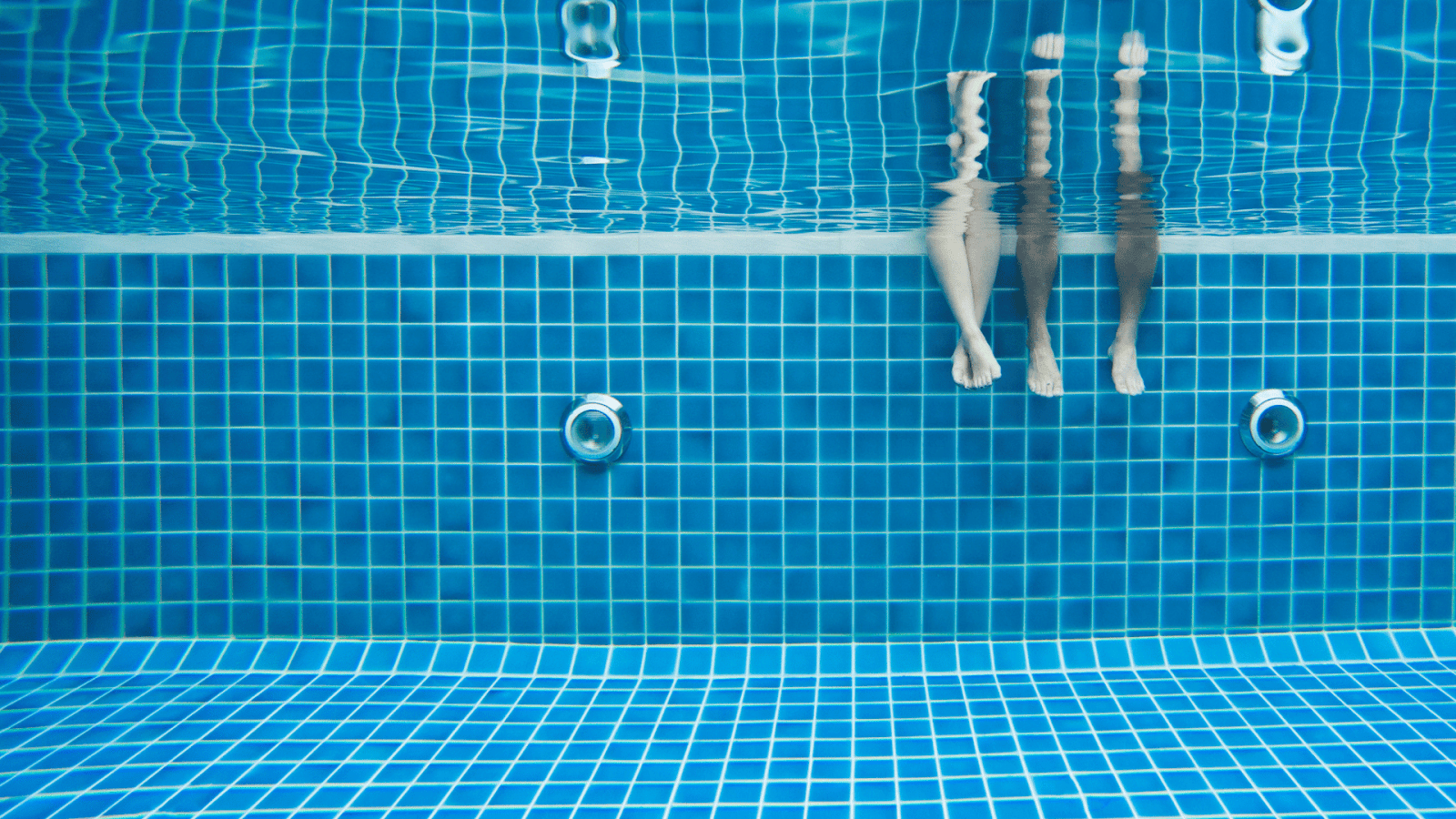 Happy adult couple in tiled pool.